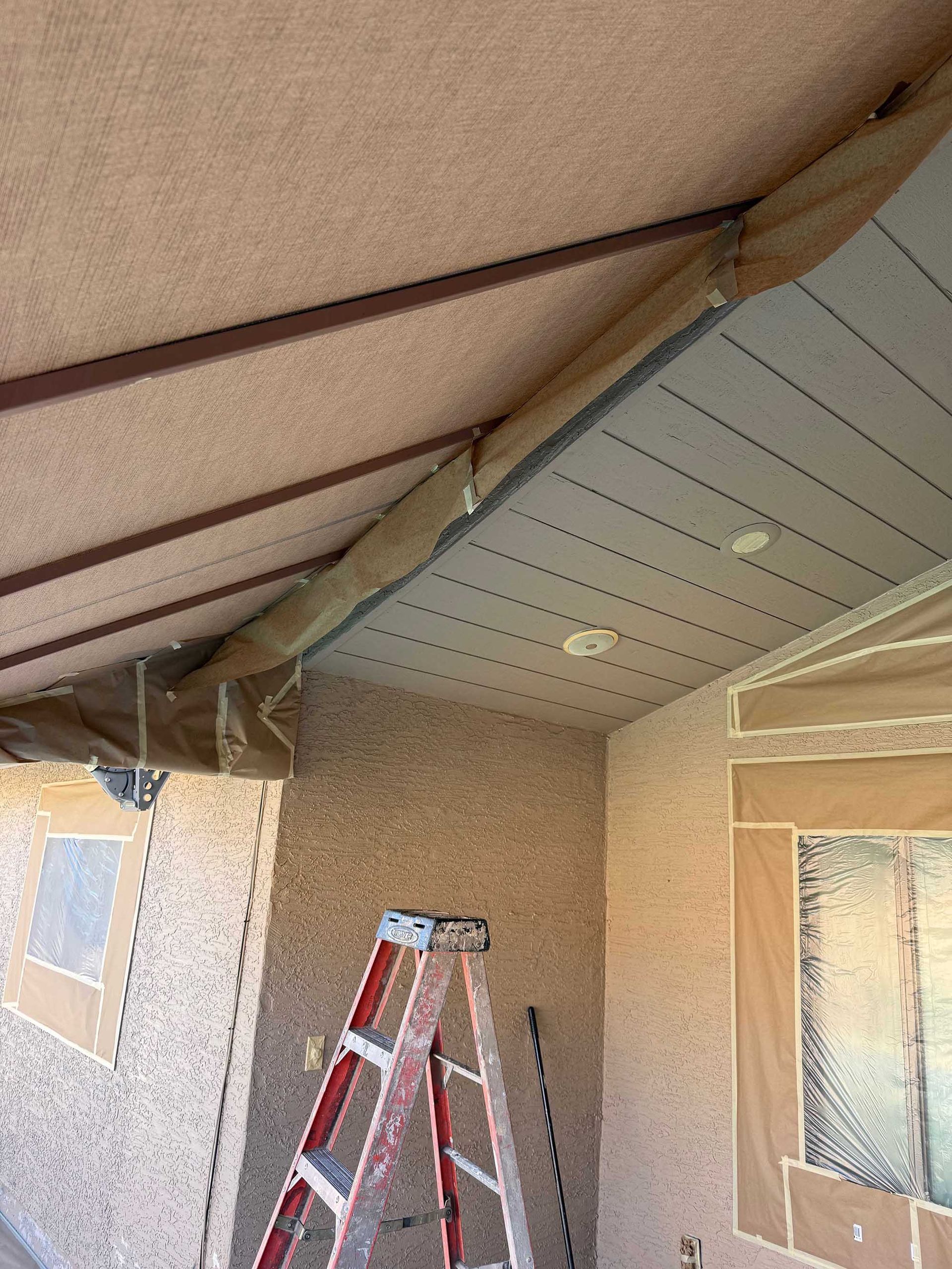 A ladder is sitting under a ceiling in a room
