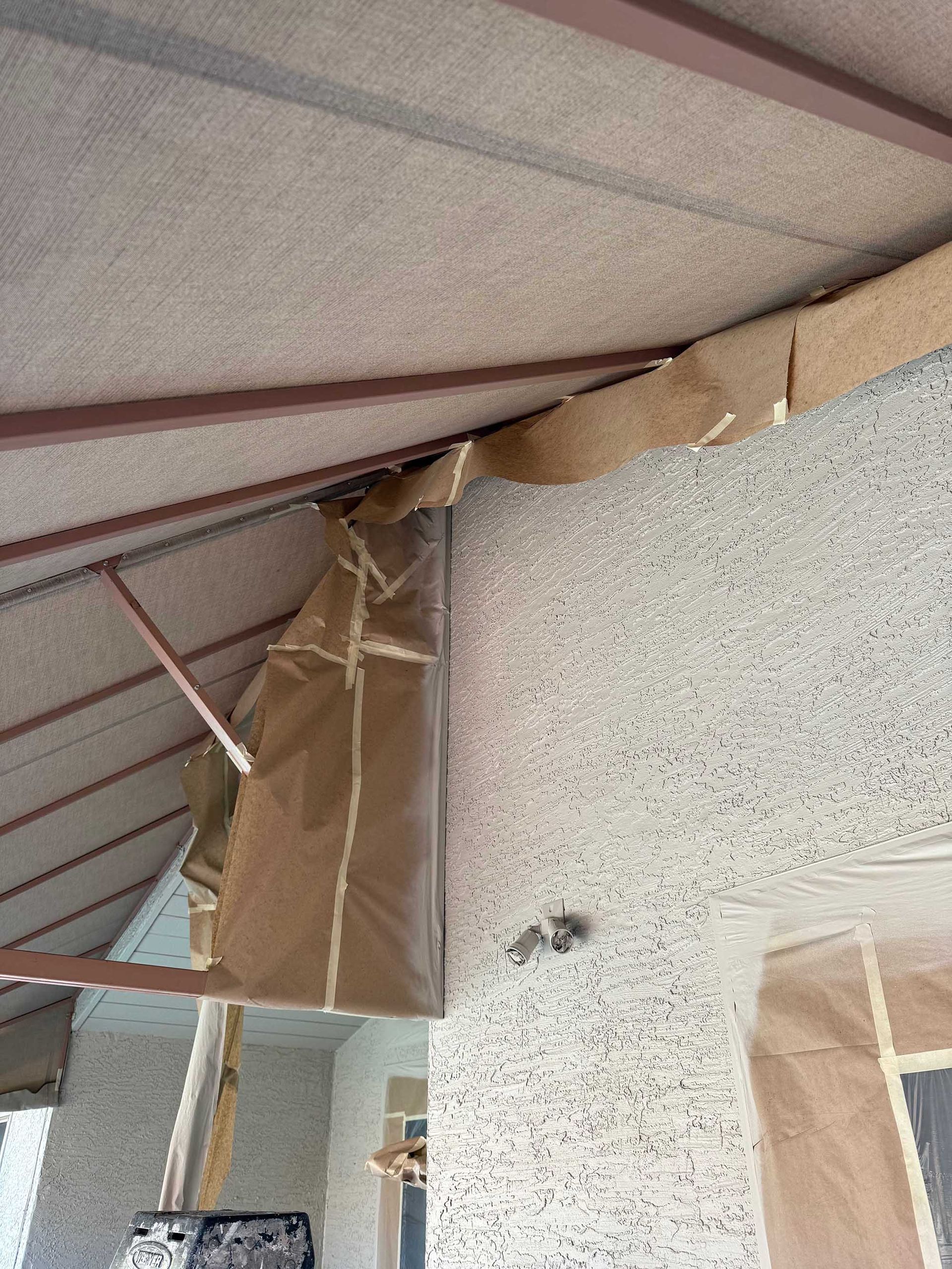 A piece of cardboard is hanging from the ceiling of a building