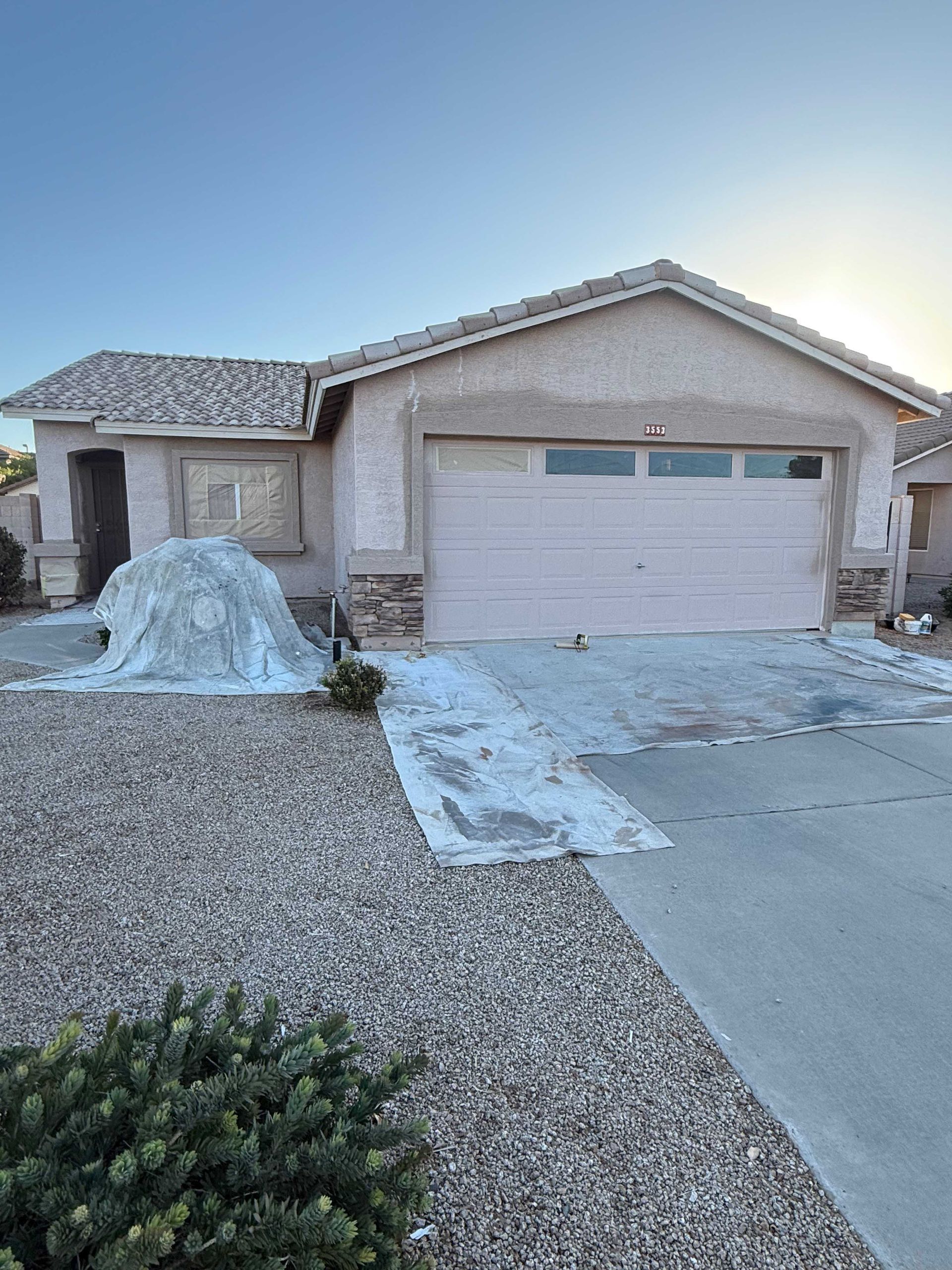 A house with a white garage door is being painted.