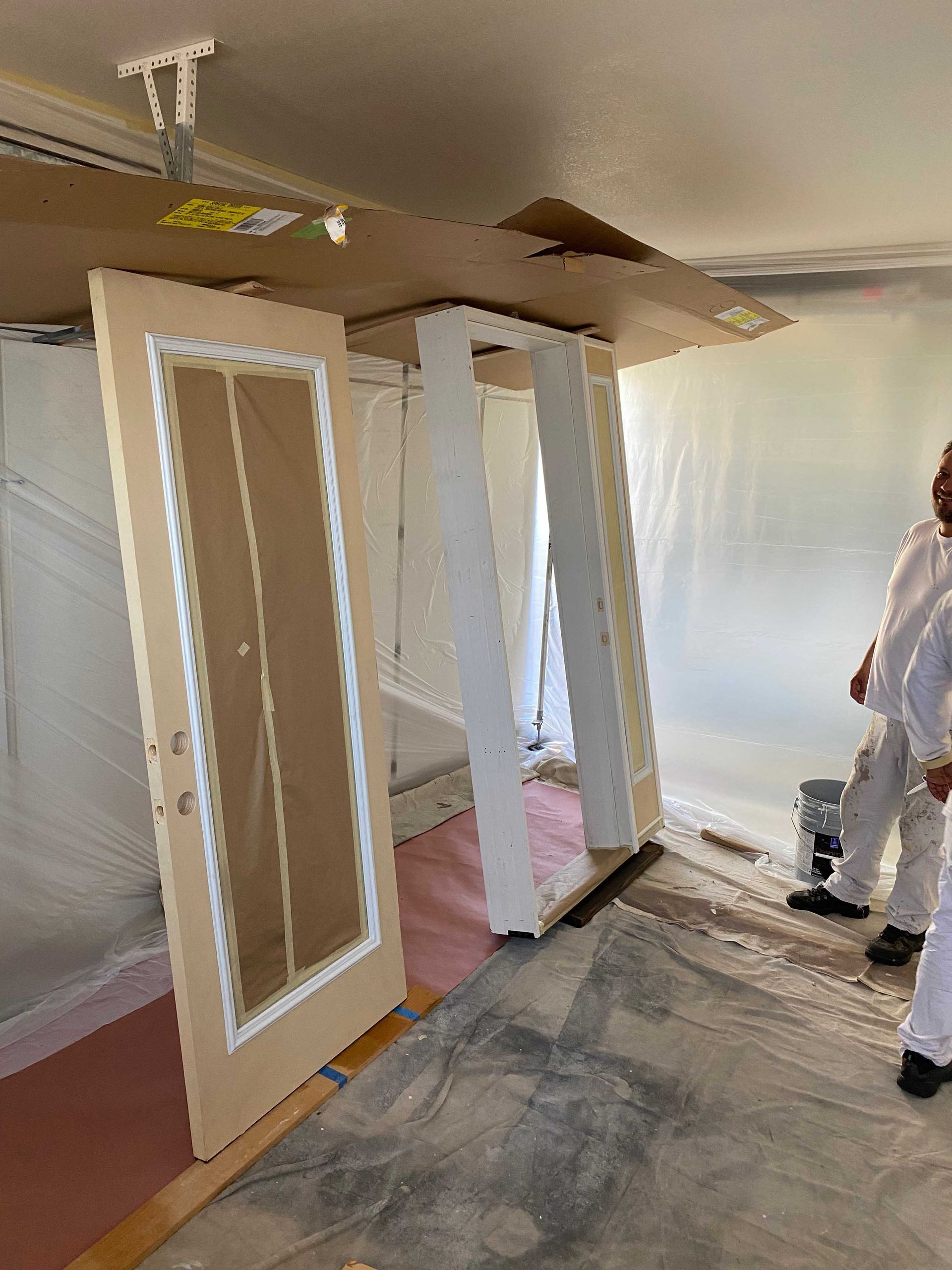 A group of people are standing in a room covered in plastic.