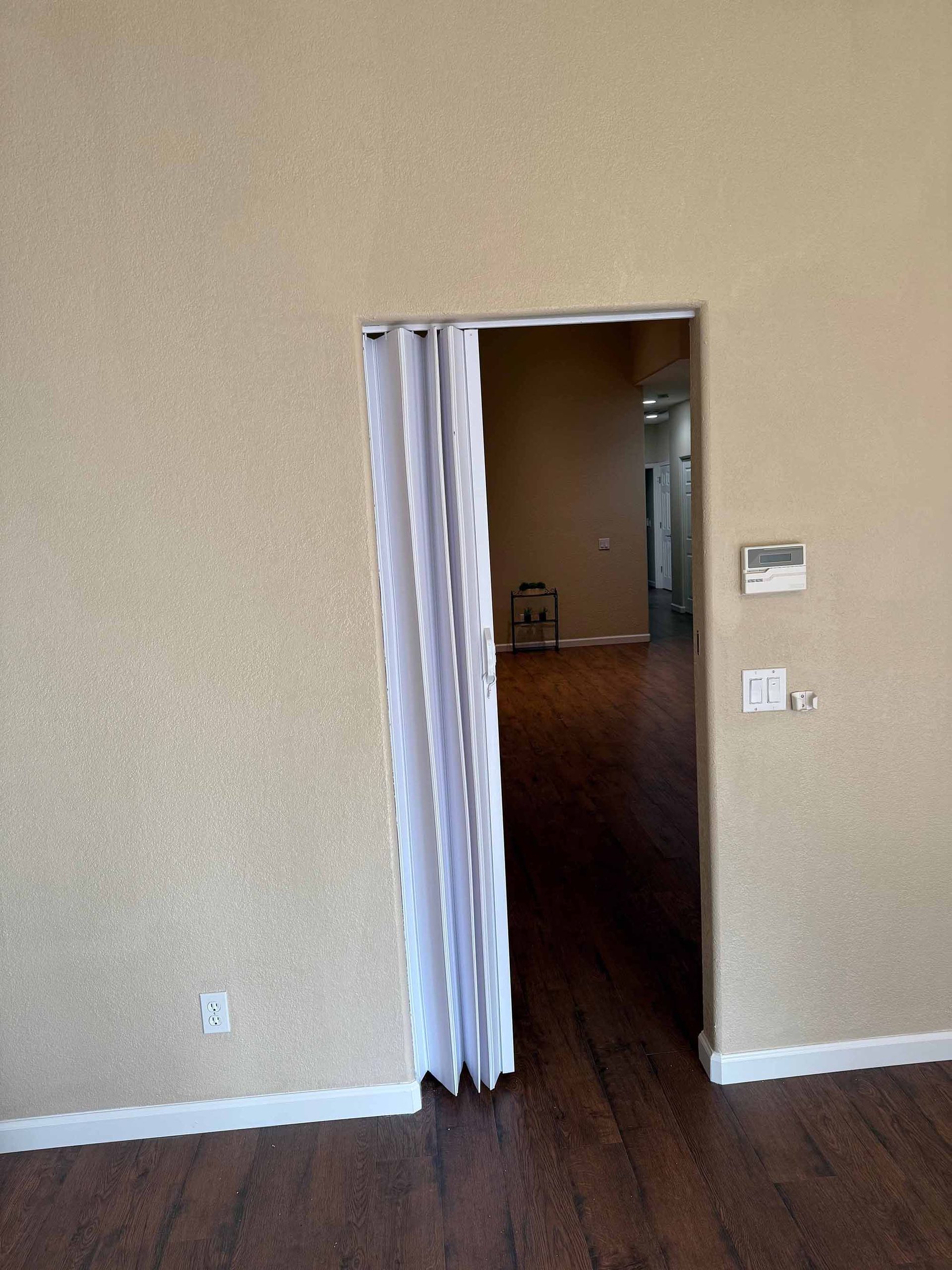 A room with a door that is open and a white curtain on it.
