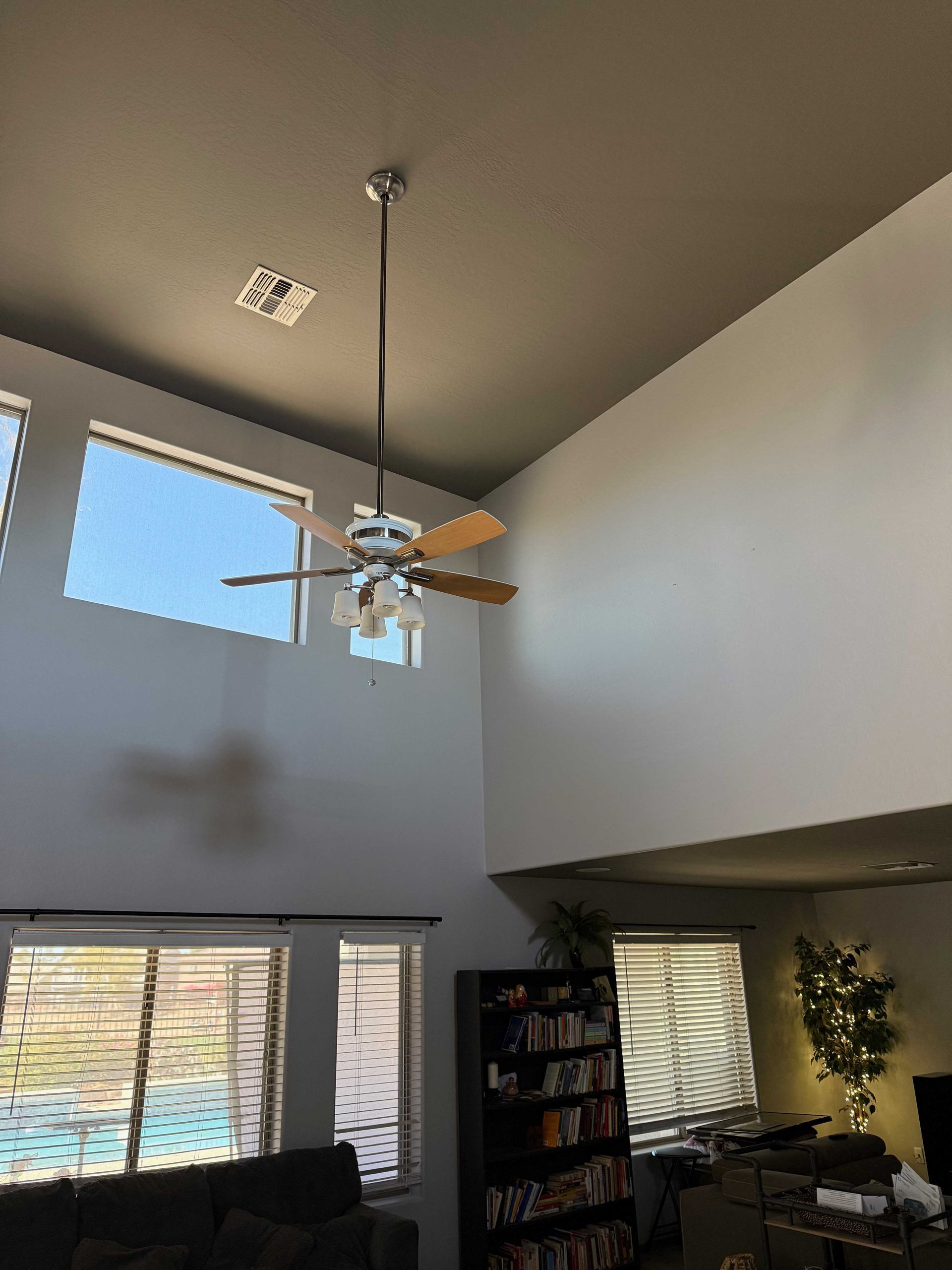 A ceiling fan is hanging from the ceiling of a living room.