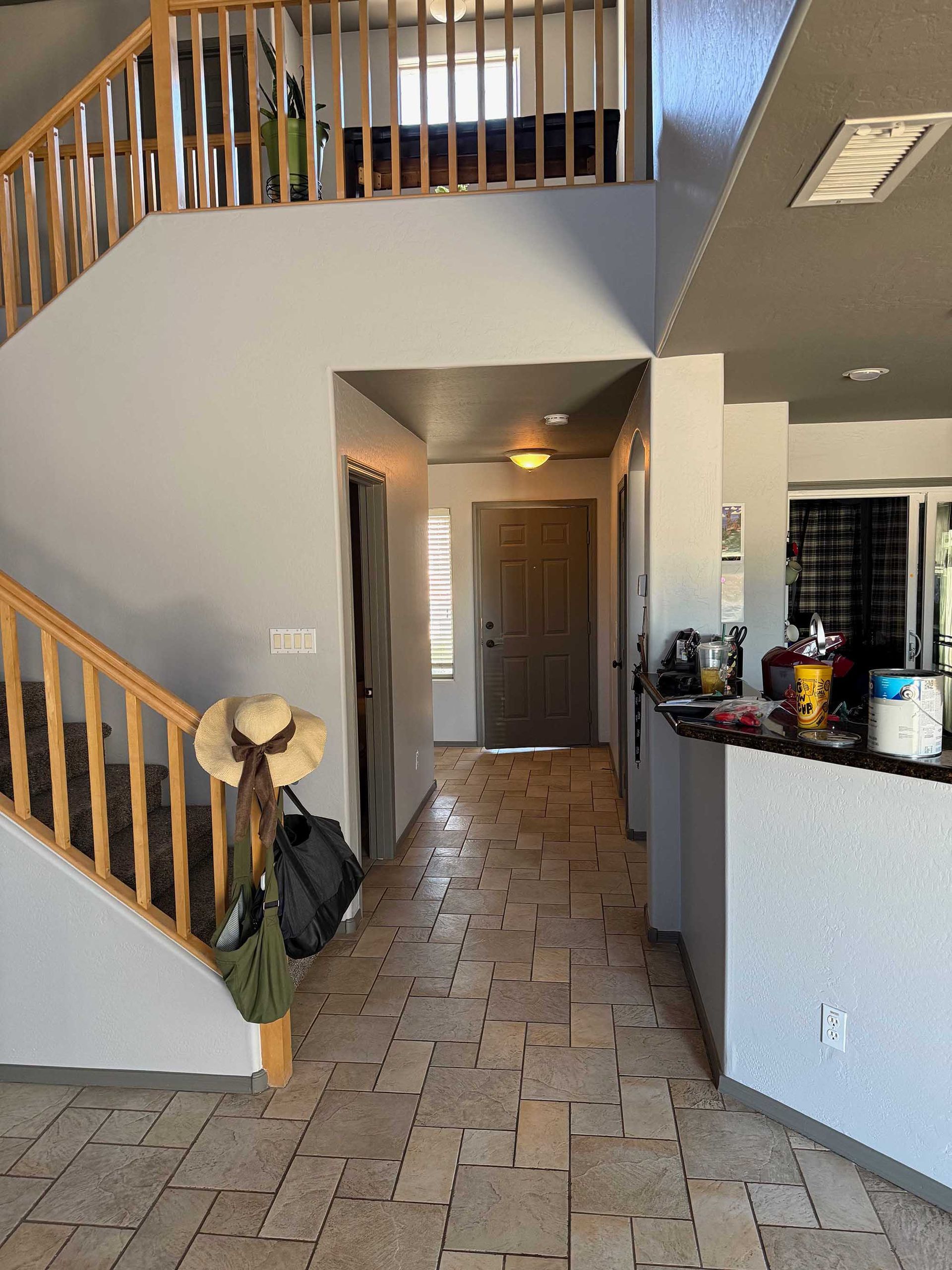 A hallway with stairs leading up to the second floor of a house.