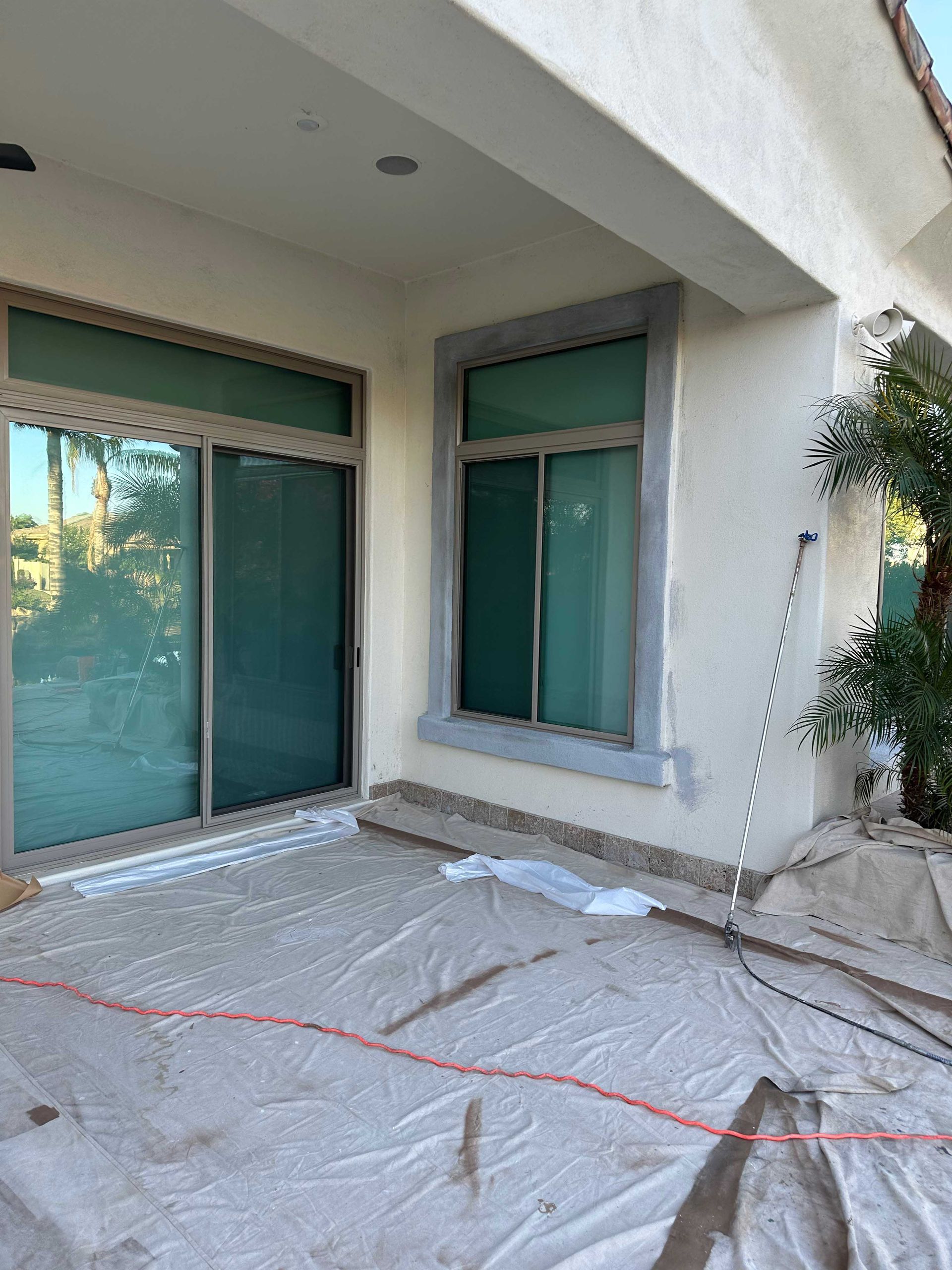 A house with a lot of windows is being painted.