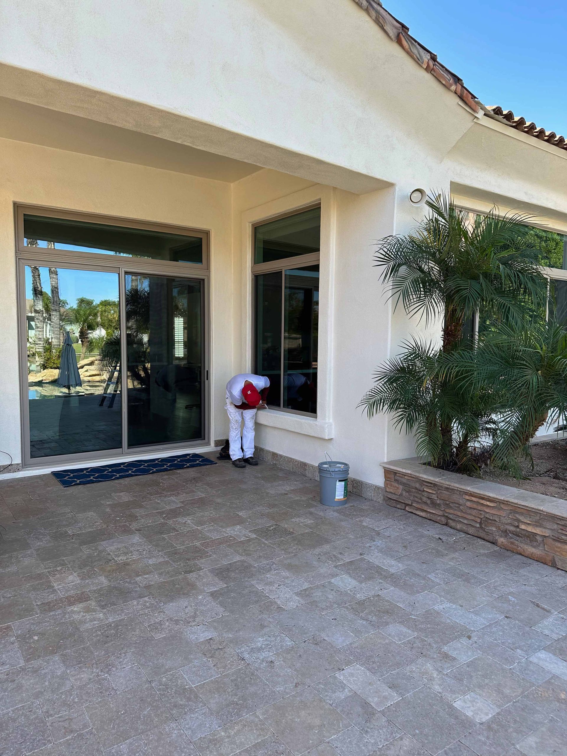 A white house with a sliding glass door and a statue of a horse in front of it.