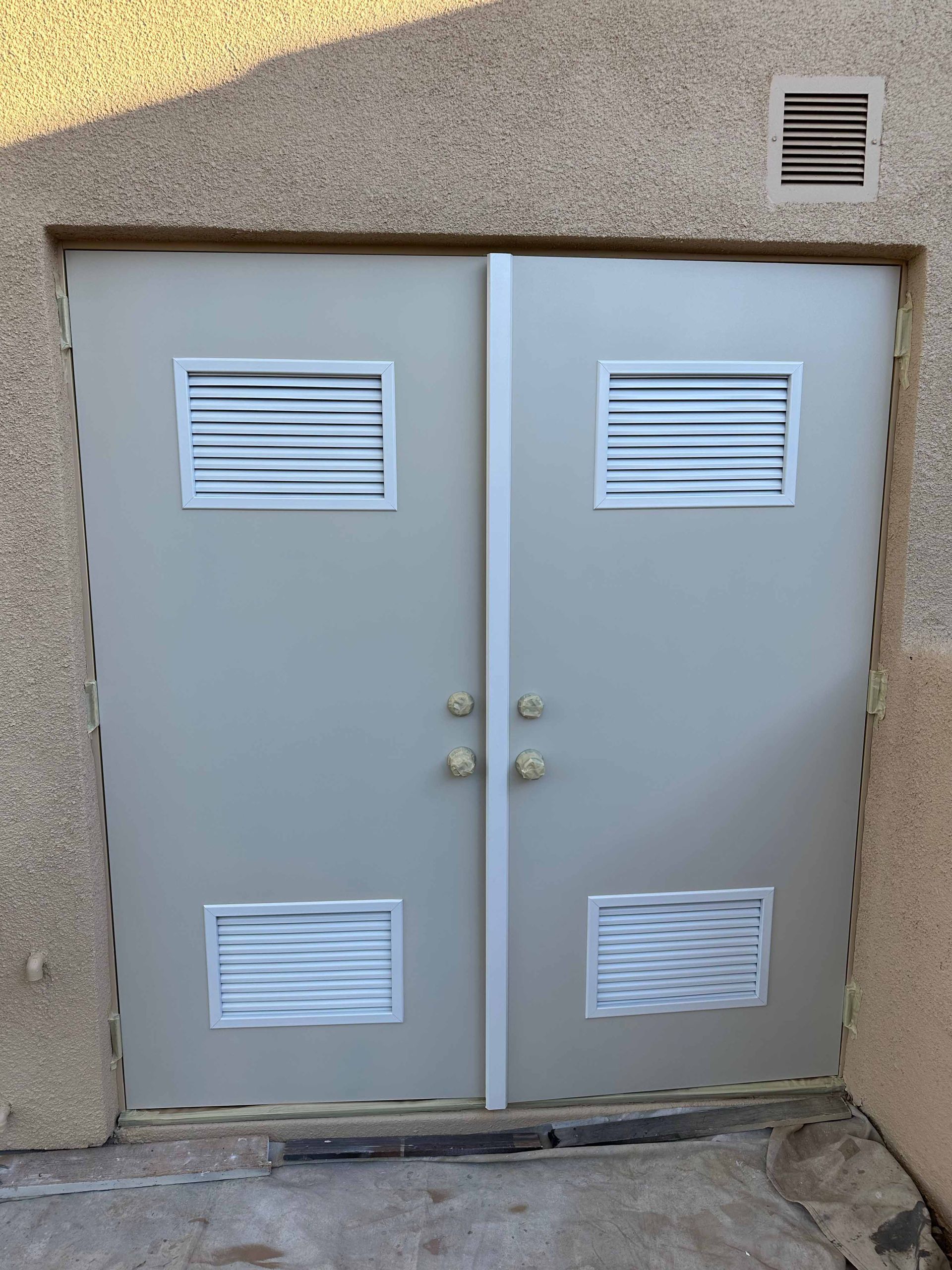 A pair of doors with ventilation holes on them