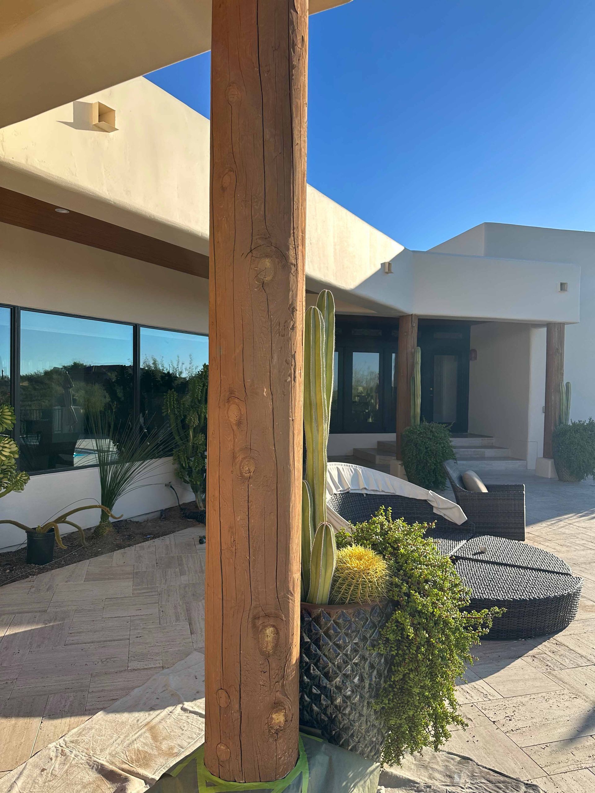 A large wooden pole is sitting in front of a house.