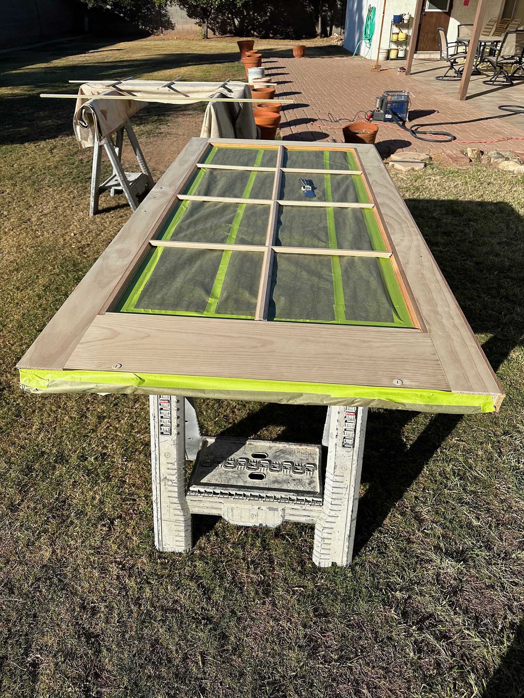 A wooden table is sitting on top of a lush green field.