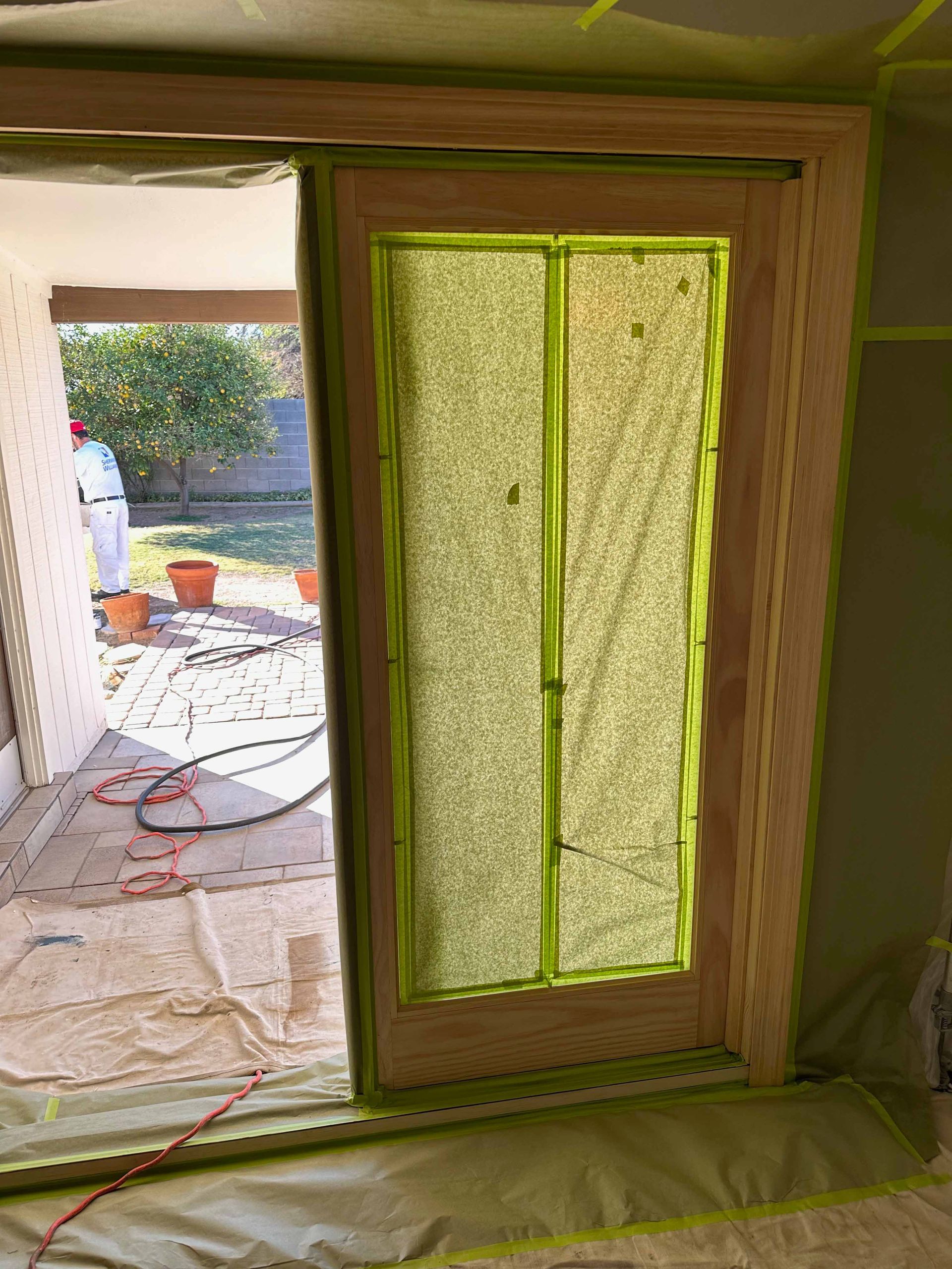 A sliding glass door is being painted in a room.