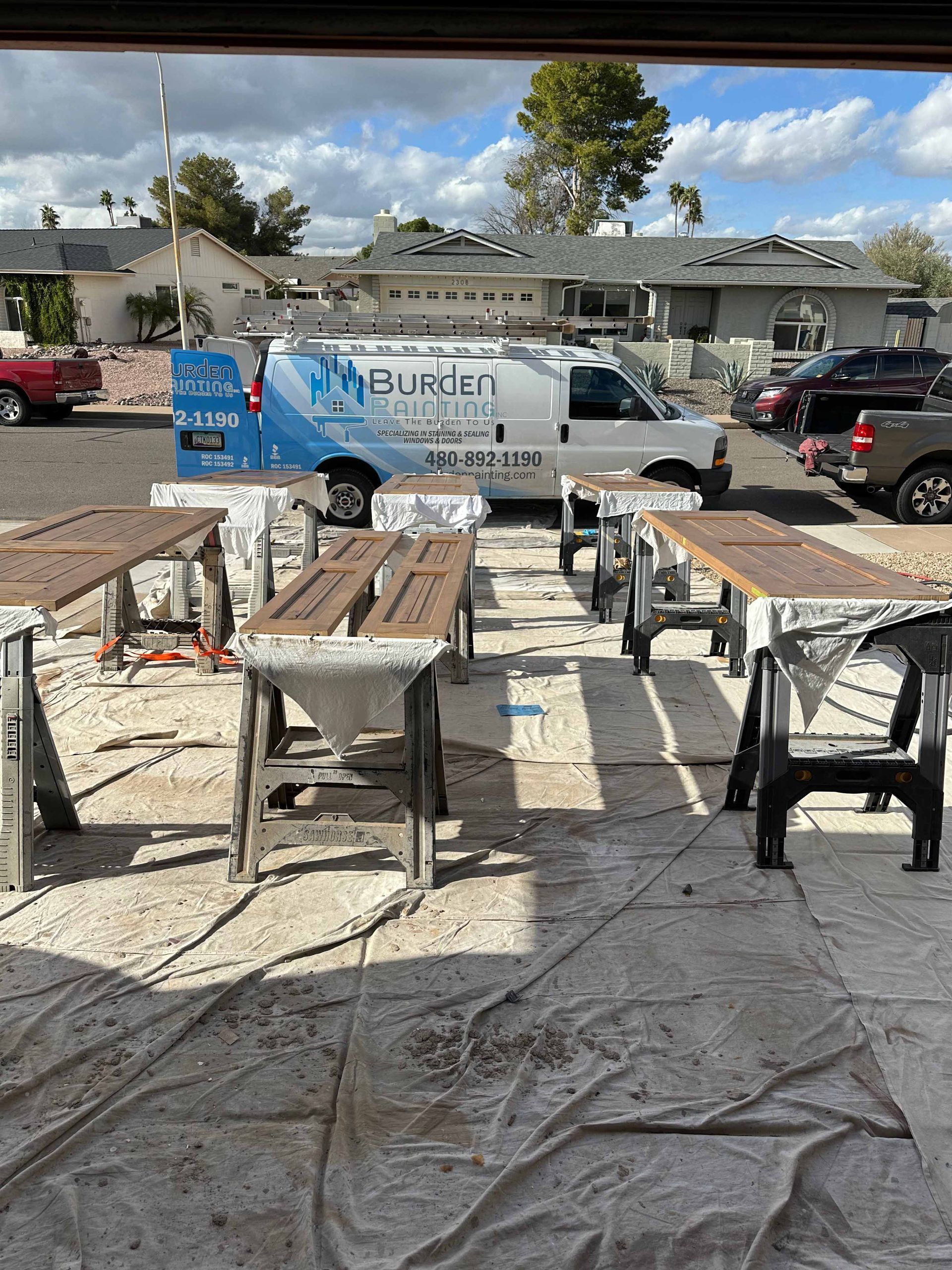 A van is parked in a parking lot next to a bunch of wooden tables.