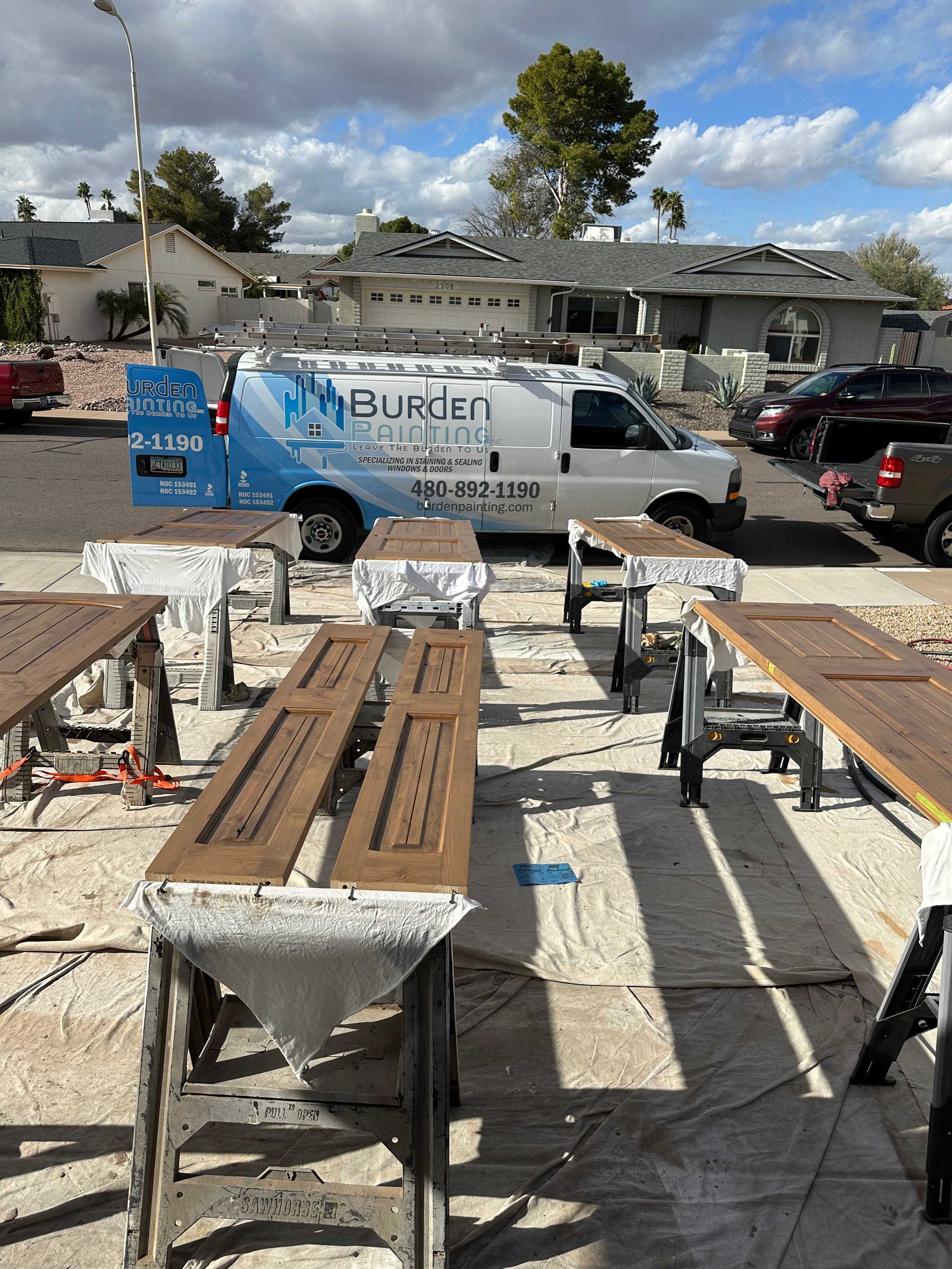 A bunch of wooden benches are sitting in front of a burger van.