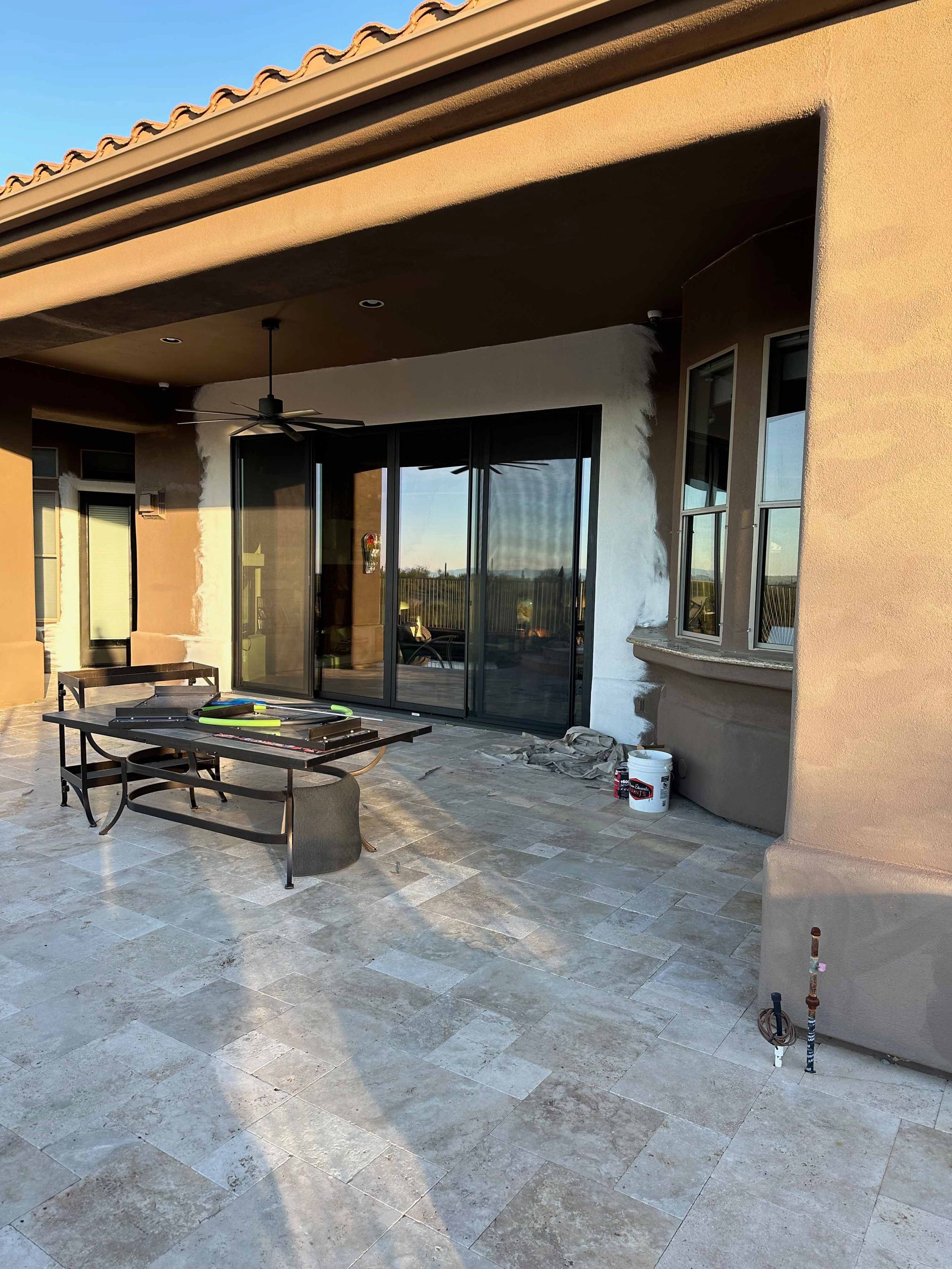 A patio with a table and chairs in front of a house