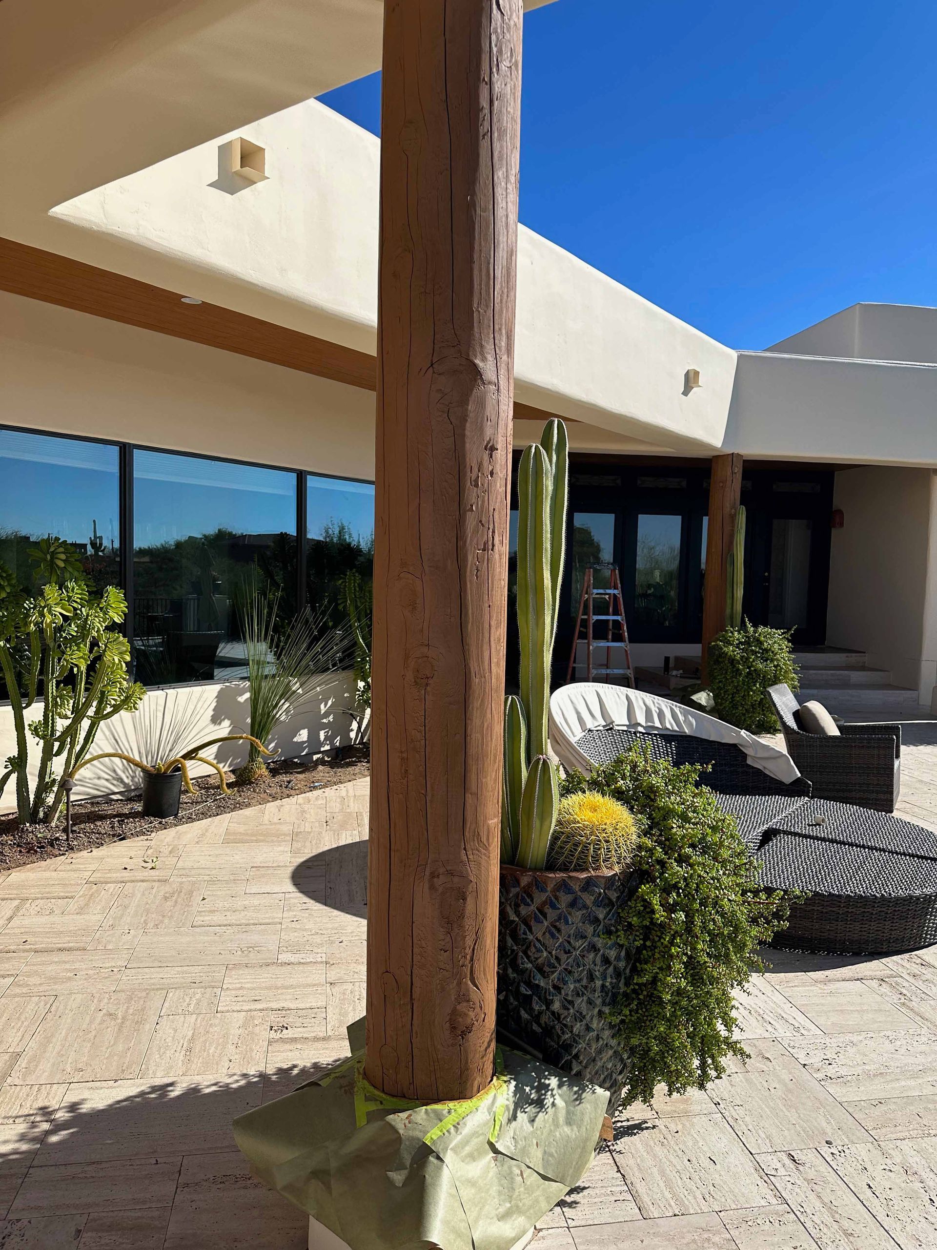 A large wooden pole is sitting in front of a house.