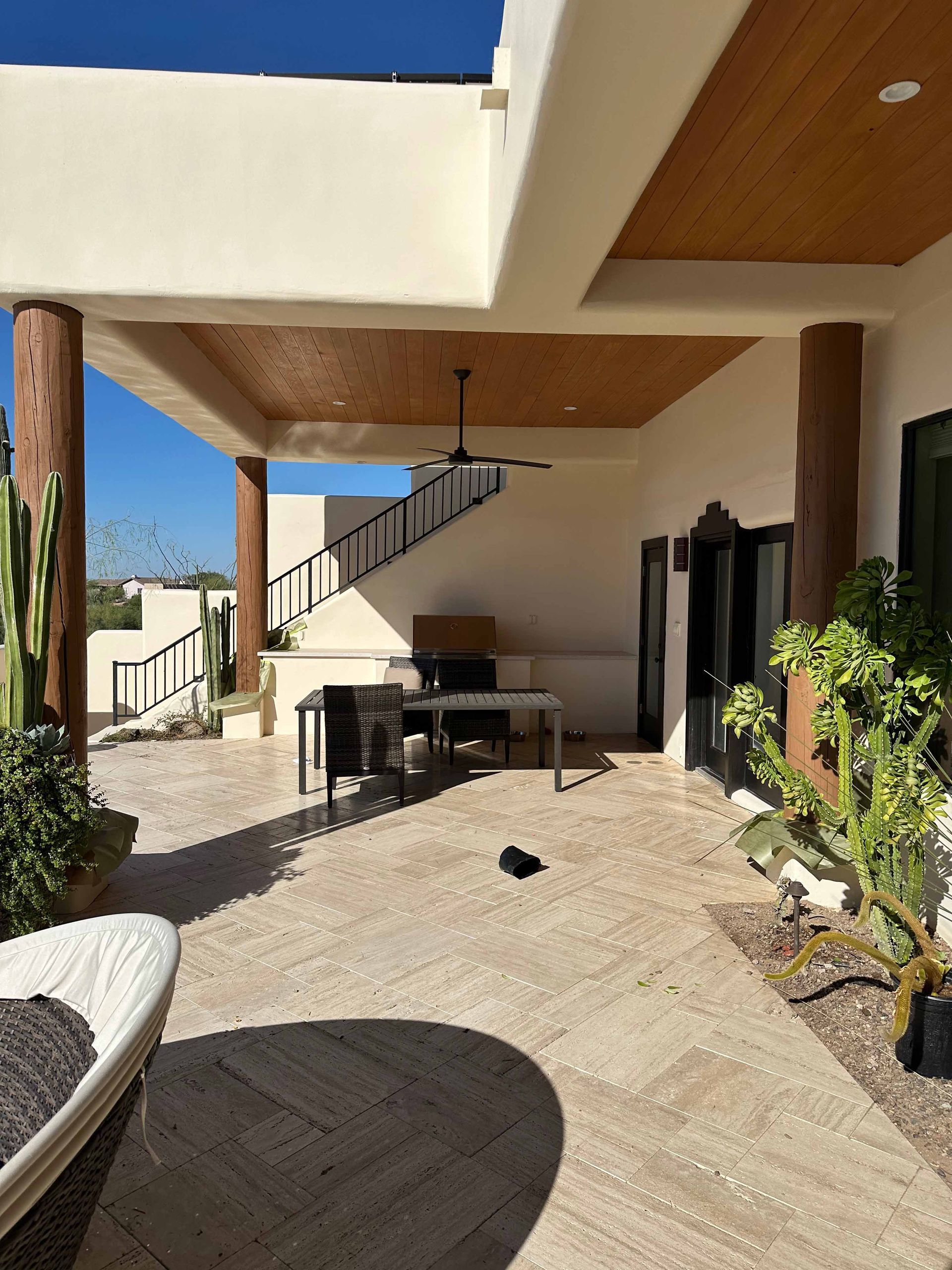 A patio with a table and chairs and a ceiling fan