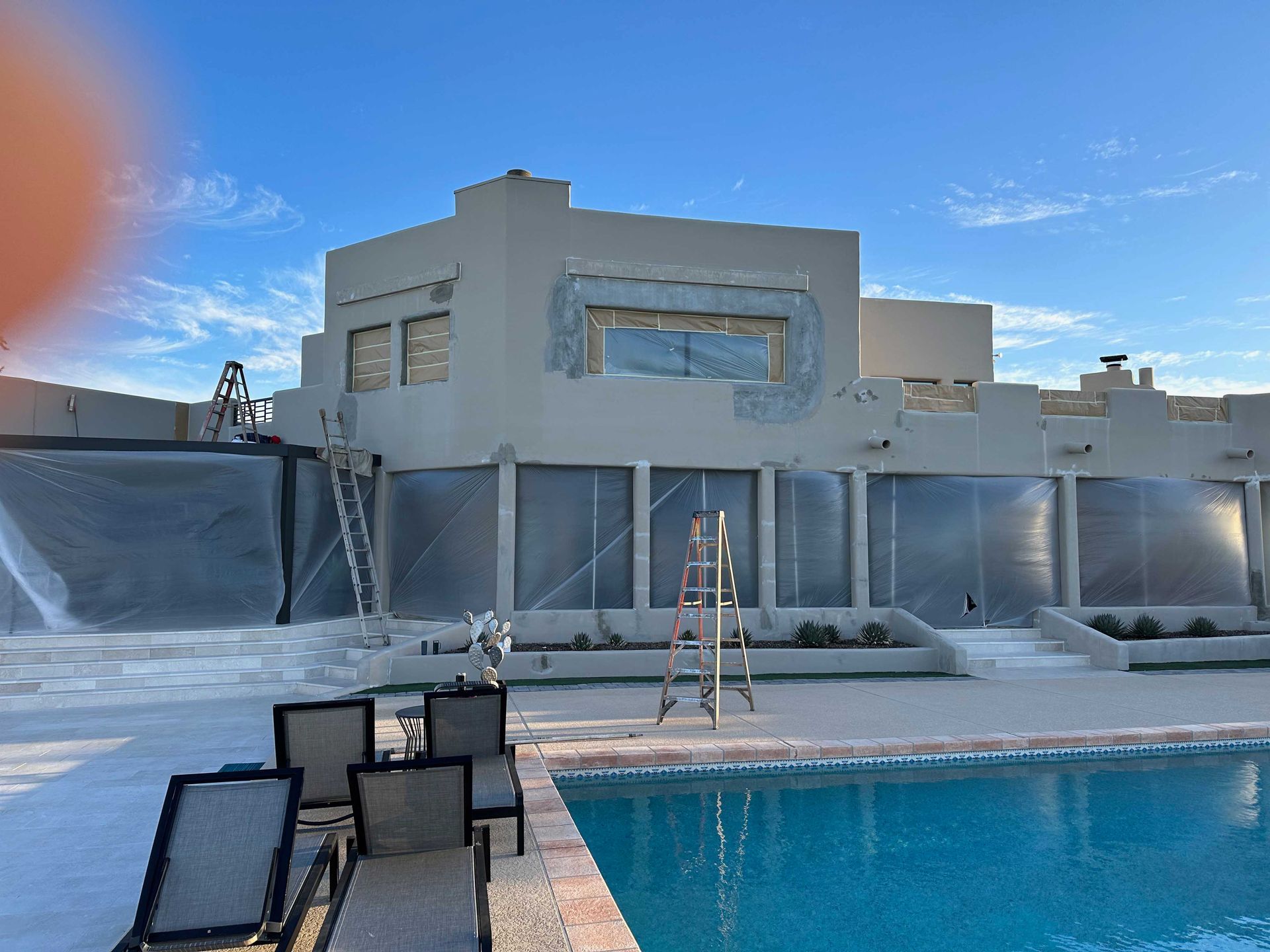 A large white house with a swimming pool in front of it.