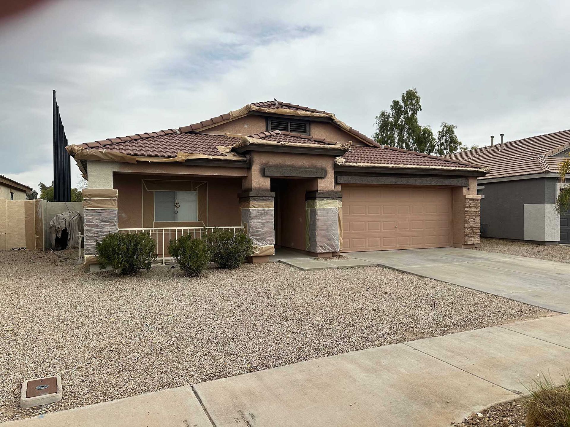 A house with a garage and a gravel driveway in front of it.