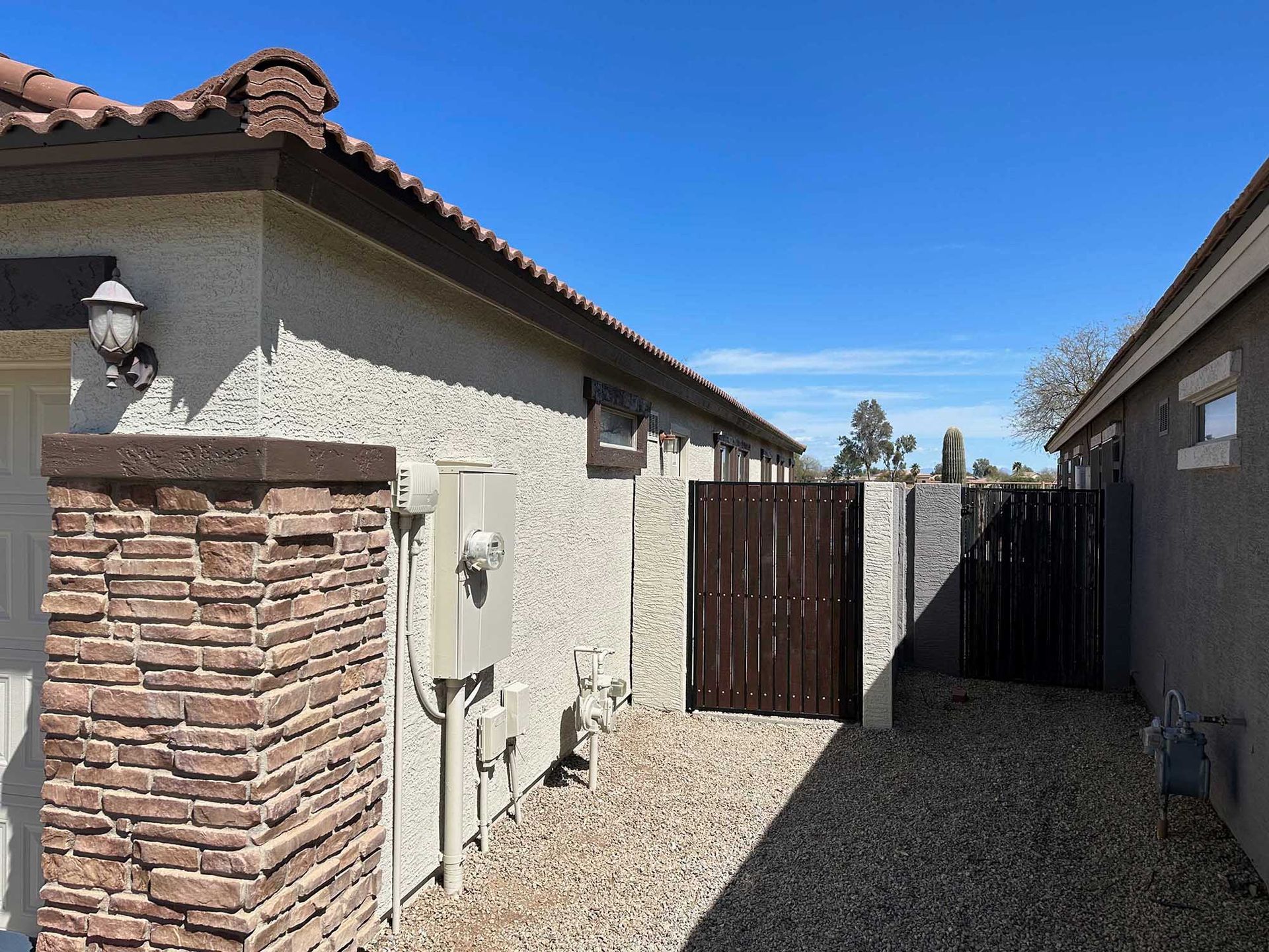 A house with a brick wall and a wooden gate.