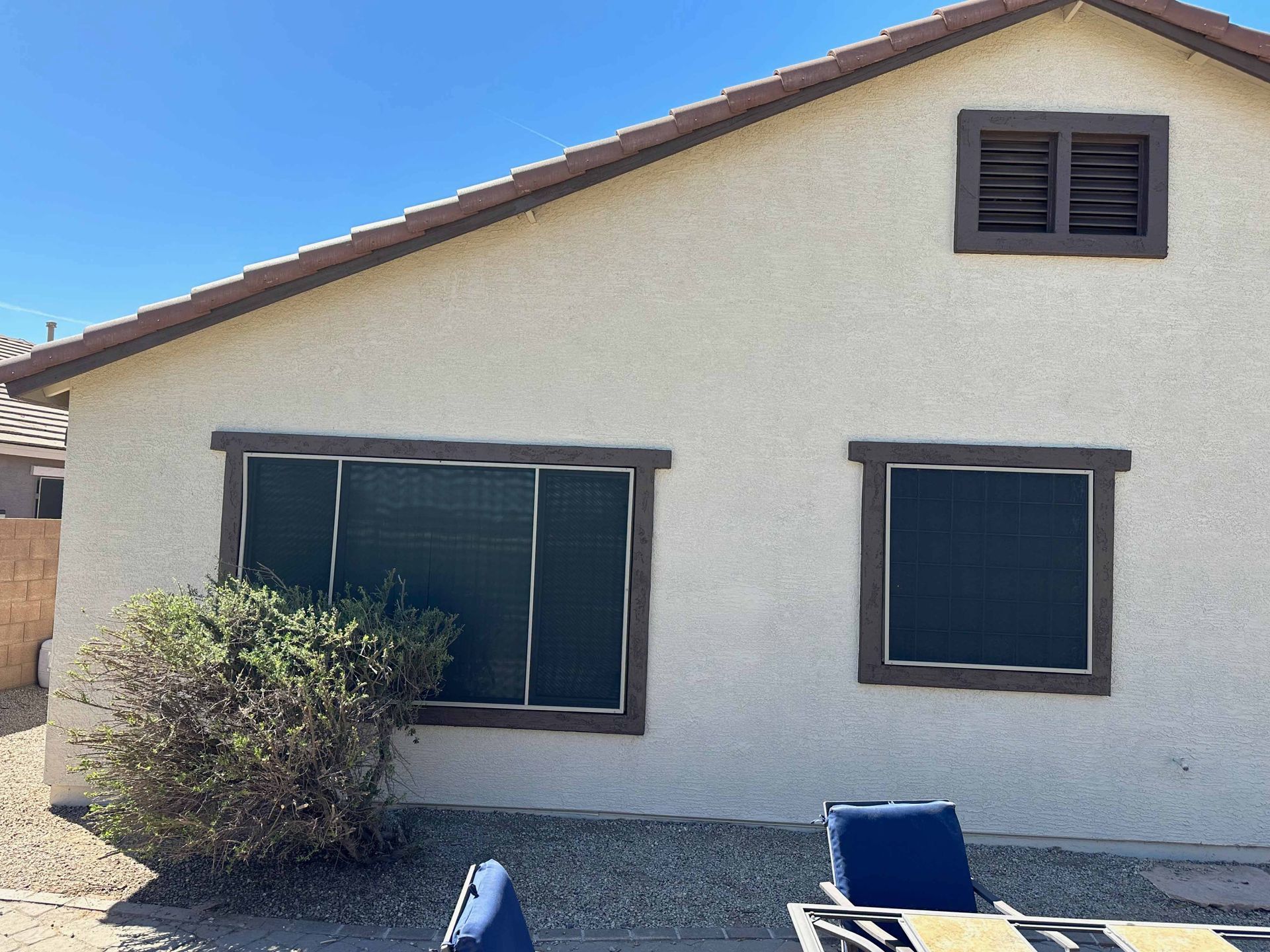 A house with a lot of windows and a table and chairs in front of it