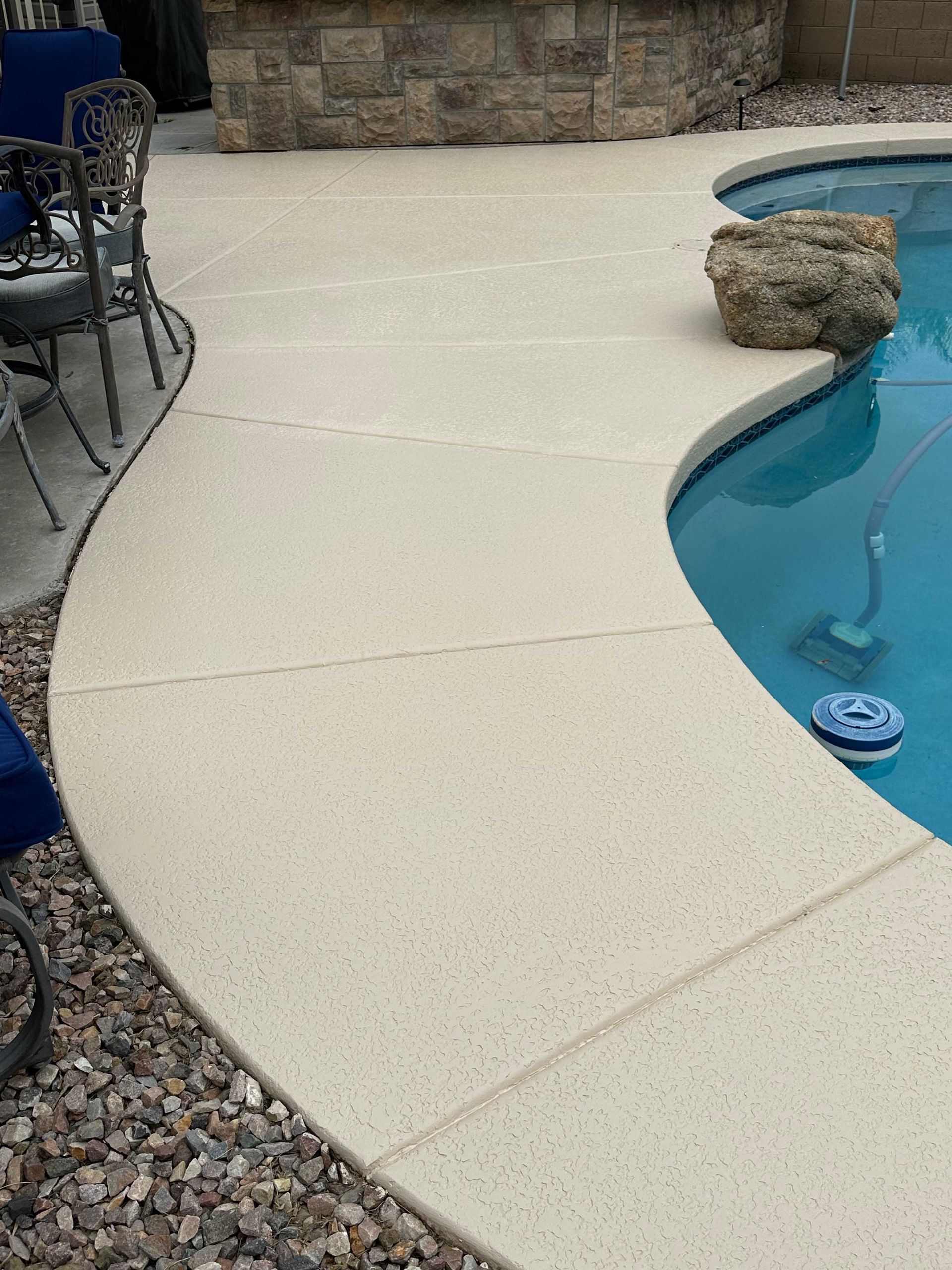 A swimming pool with a table and chairs next to it