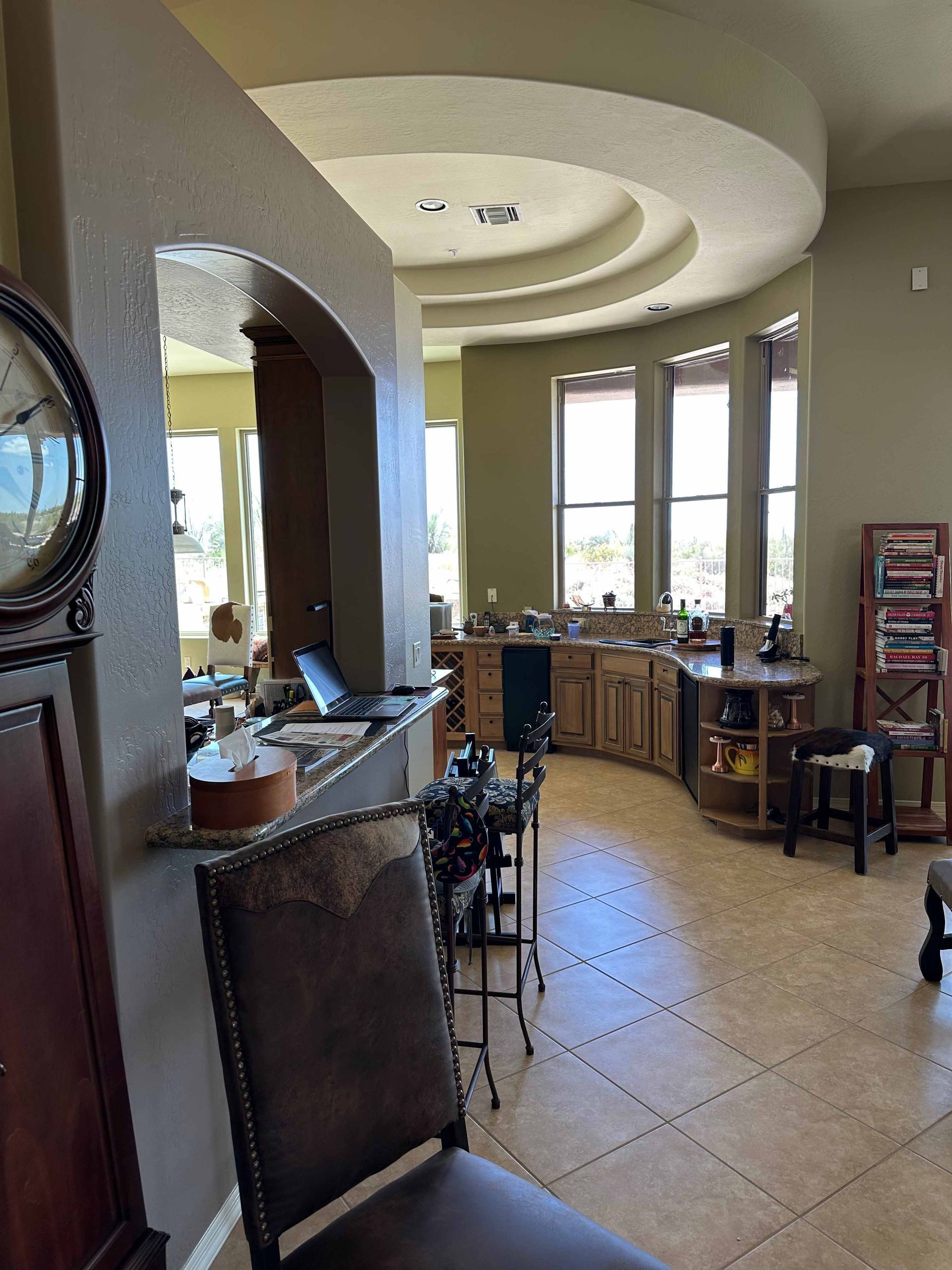 A living room with a clock on the wall and a chair.