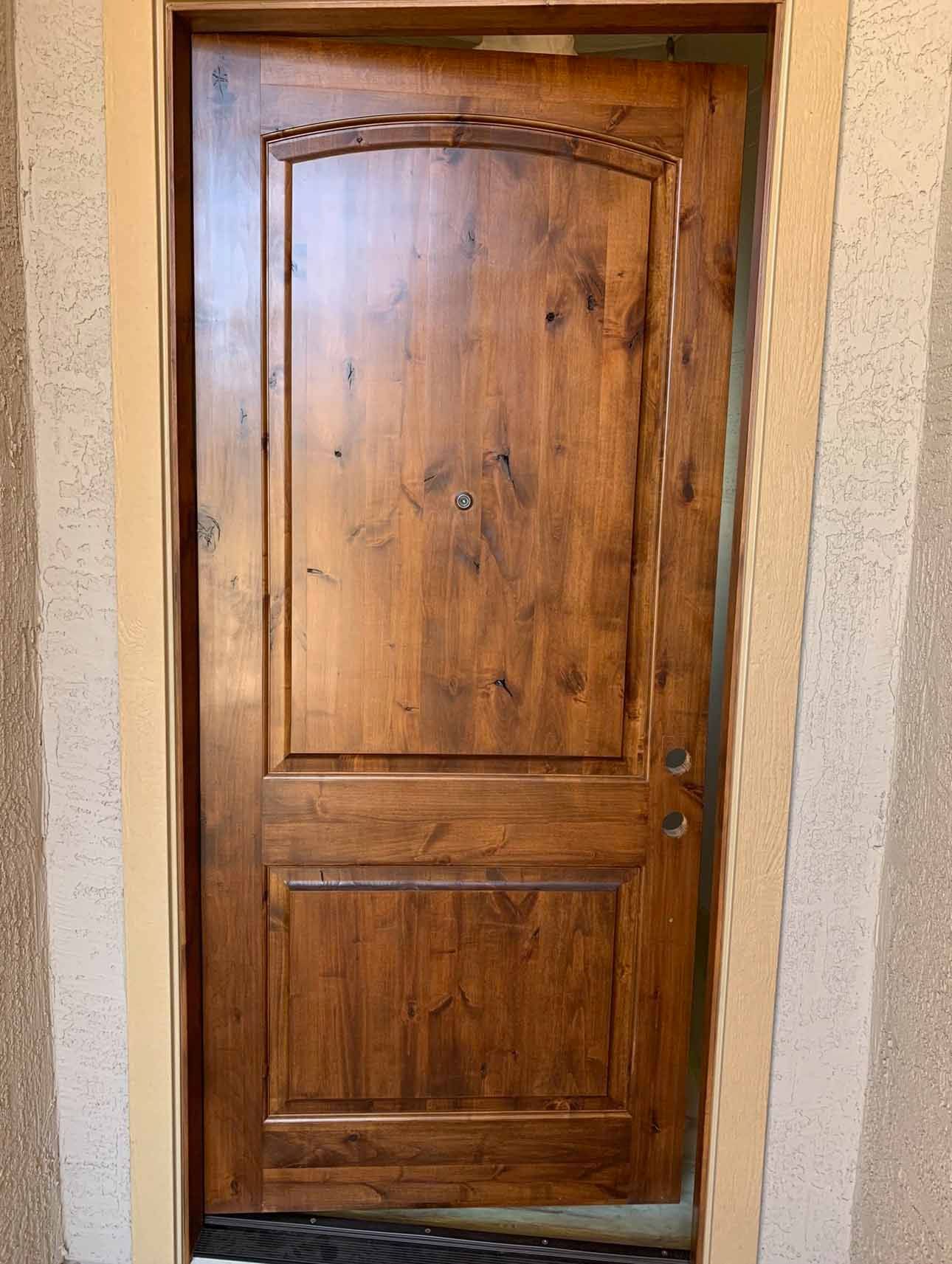 A wooden door is sitting on the side of a building.