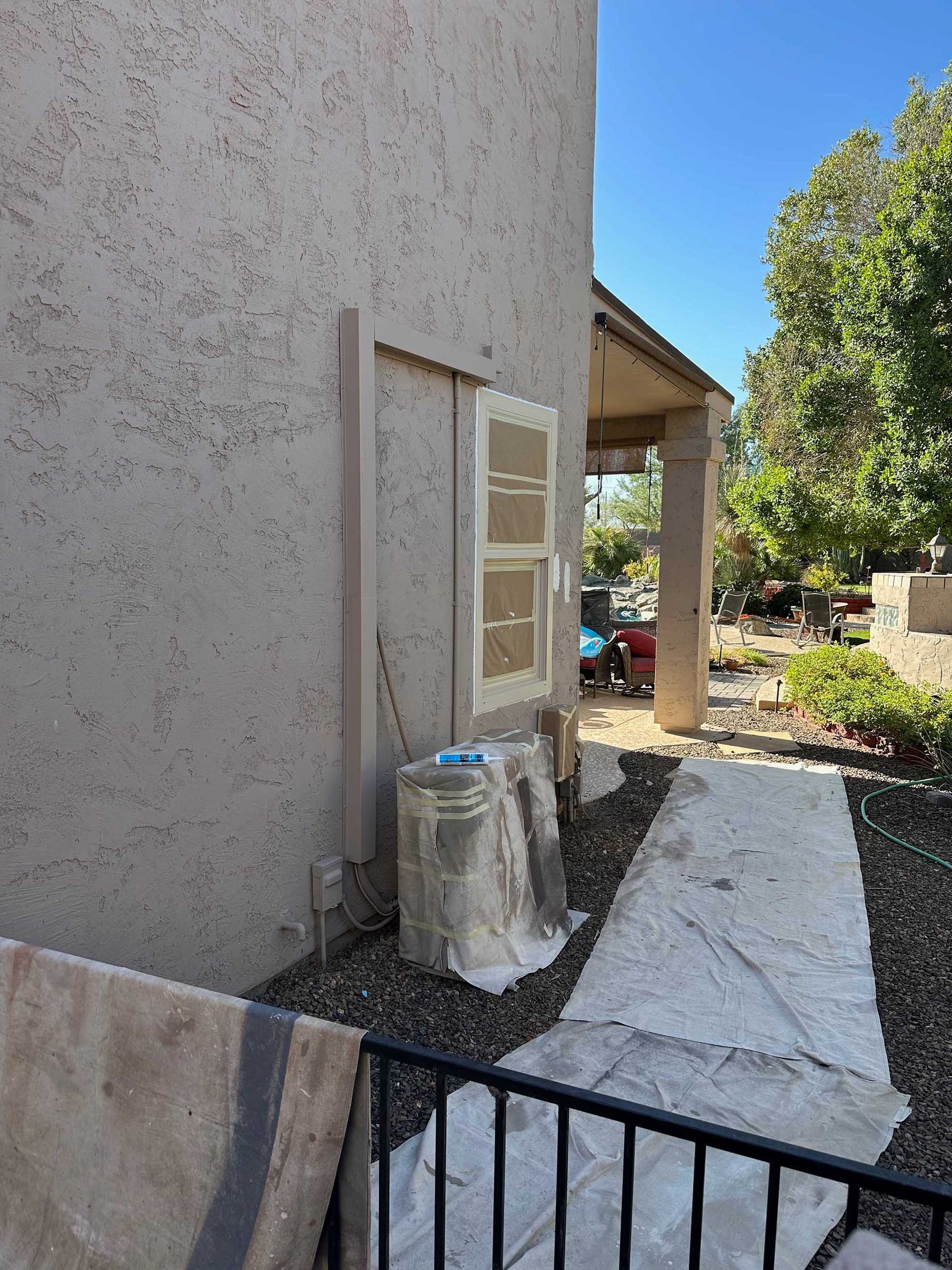 A door is being painted on the side of a house.