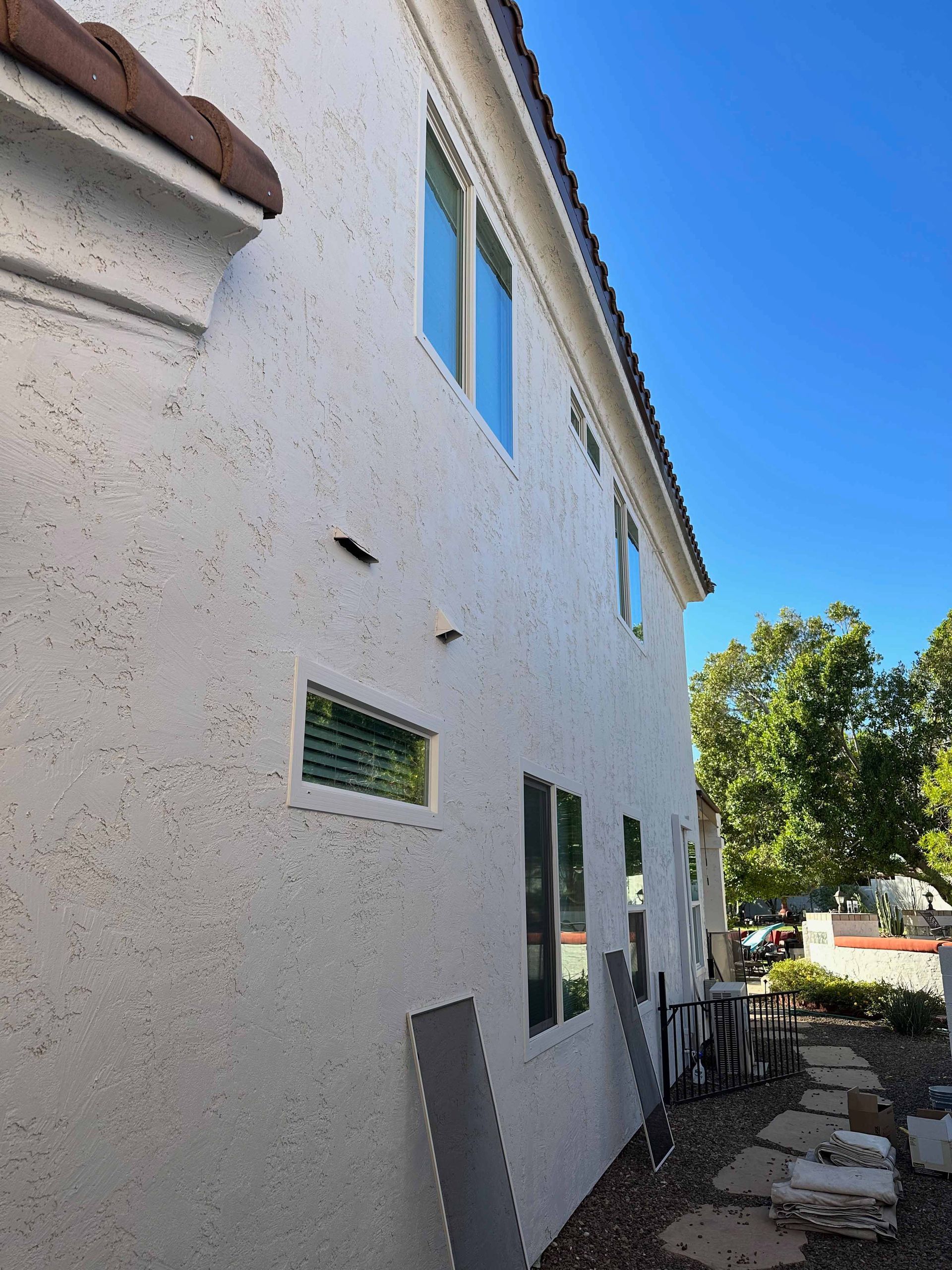A white house with a lot of windows and a blue sky in the background.