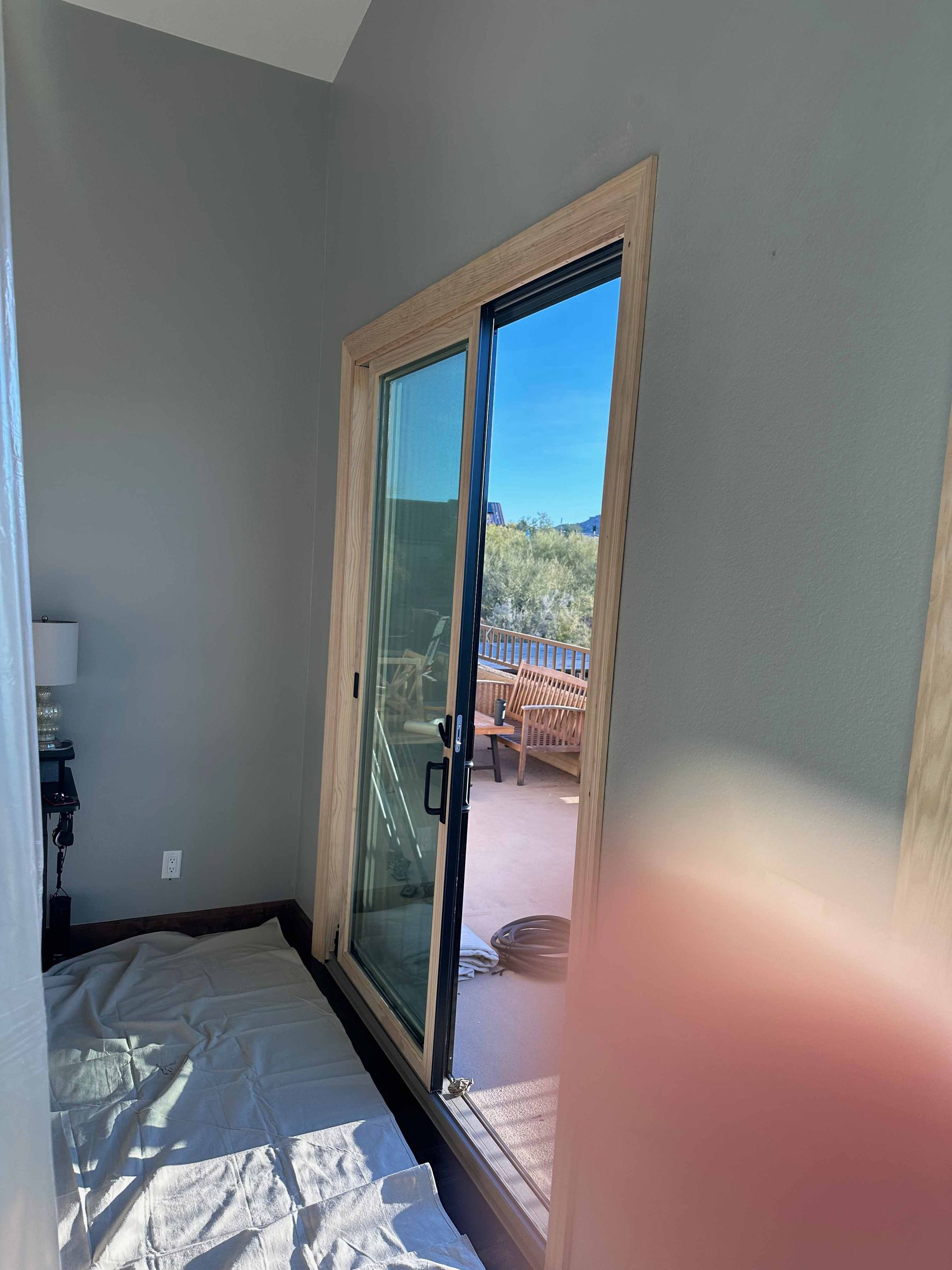 A room with a sliding glass door leading to a balcony.