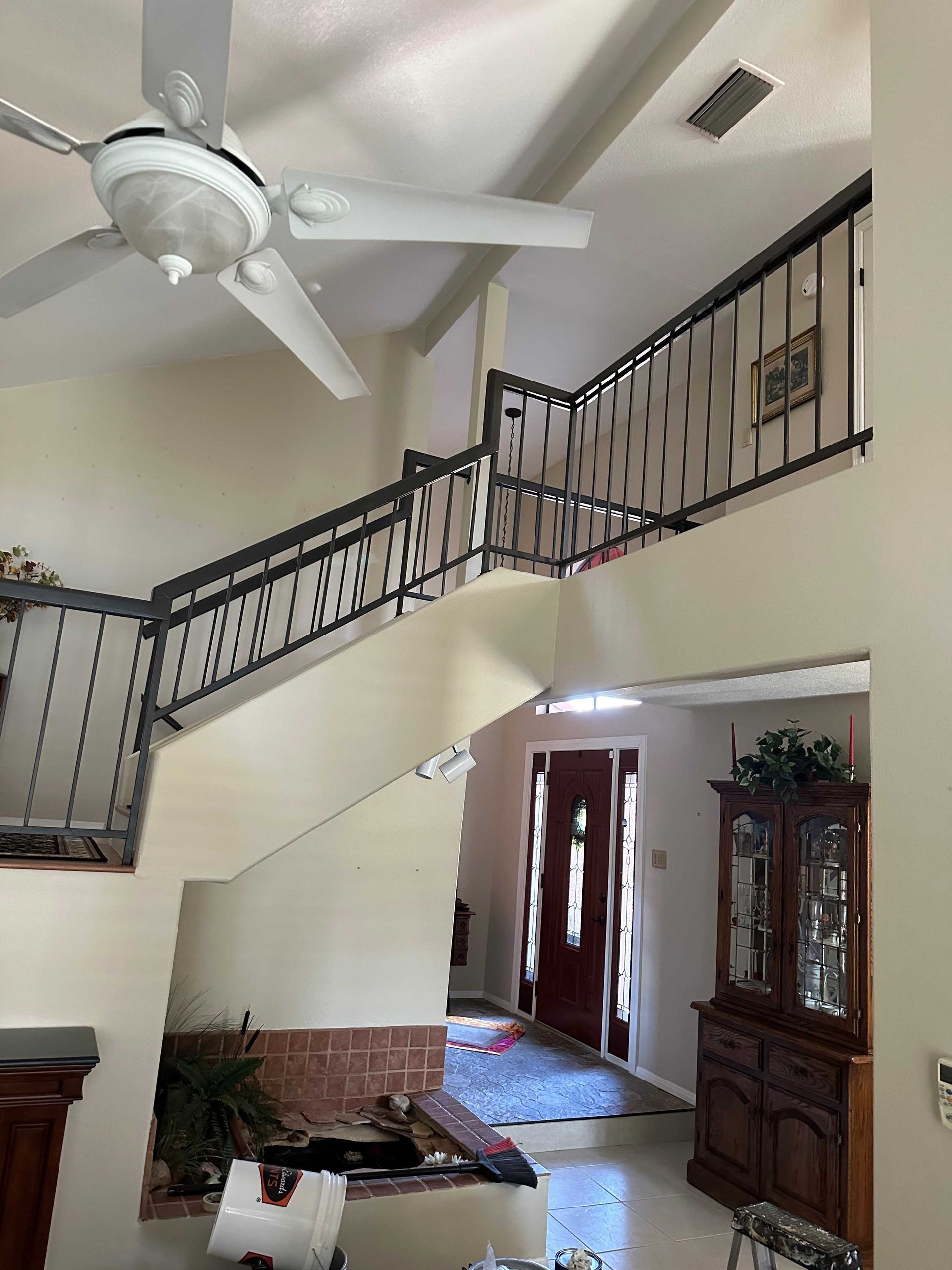 A living room with a staircase and a ceiling fan
