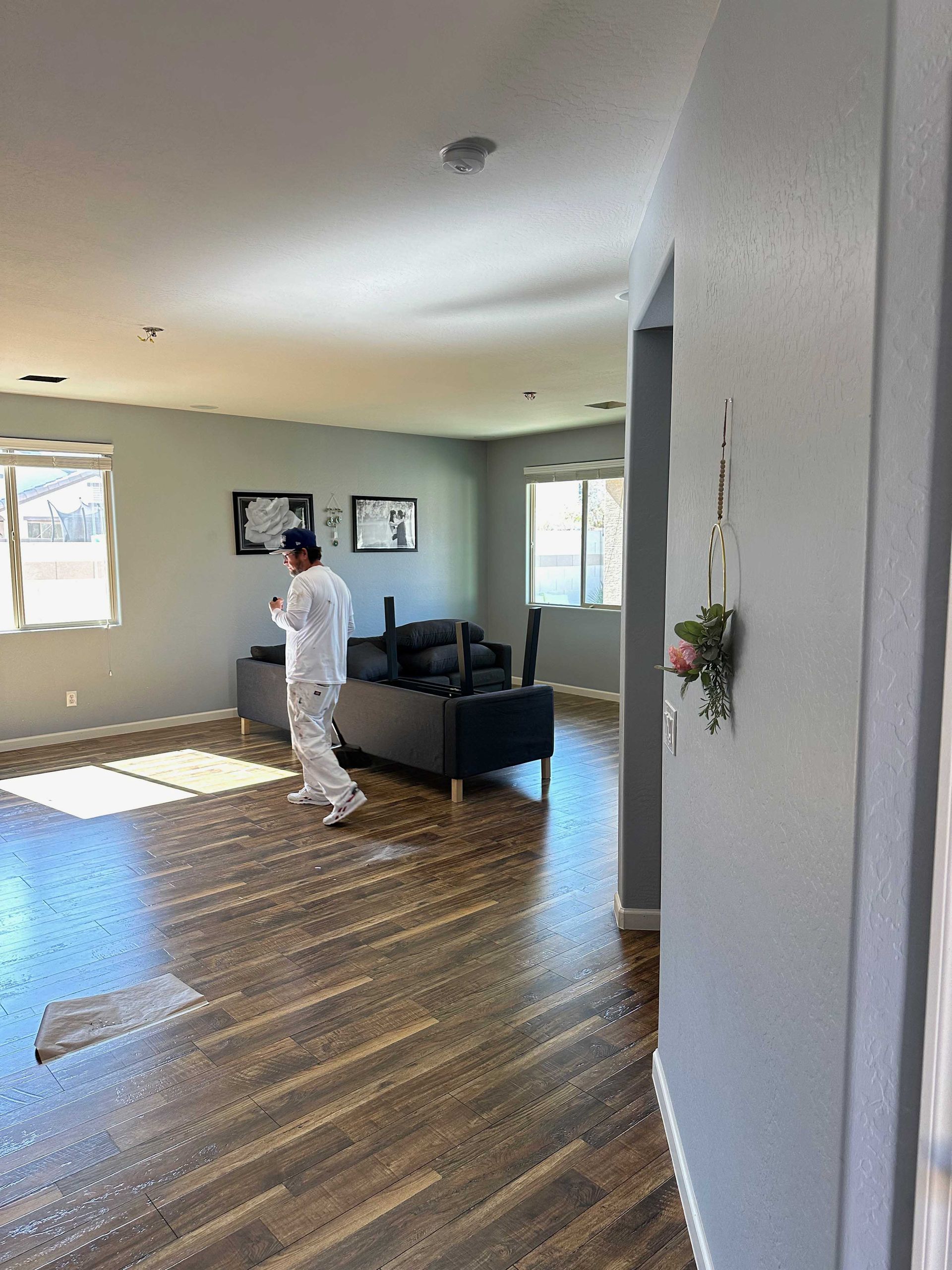 A man is standing in a living room next to a couch.