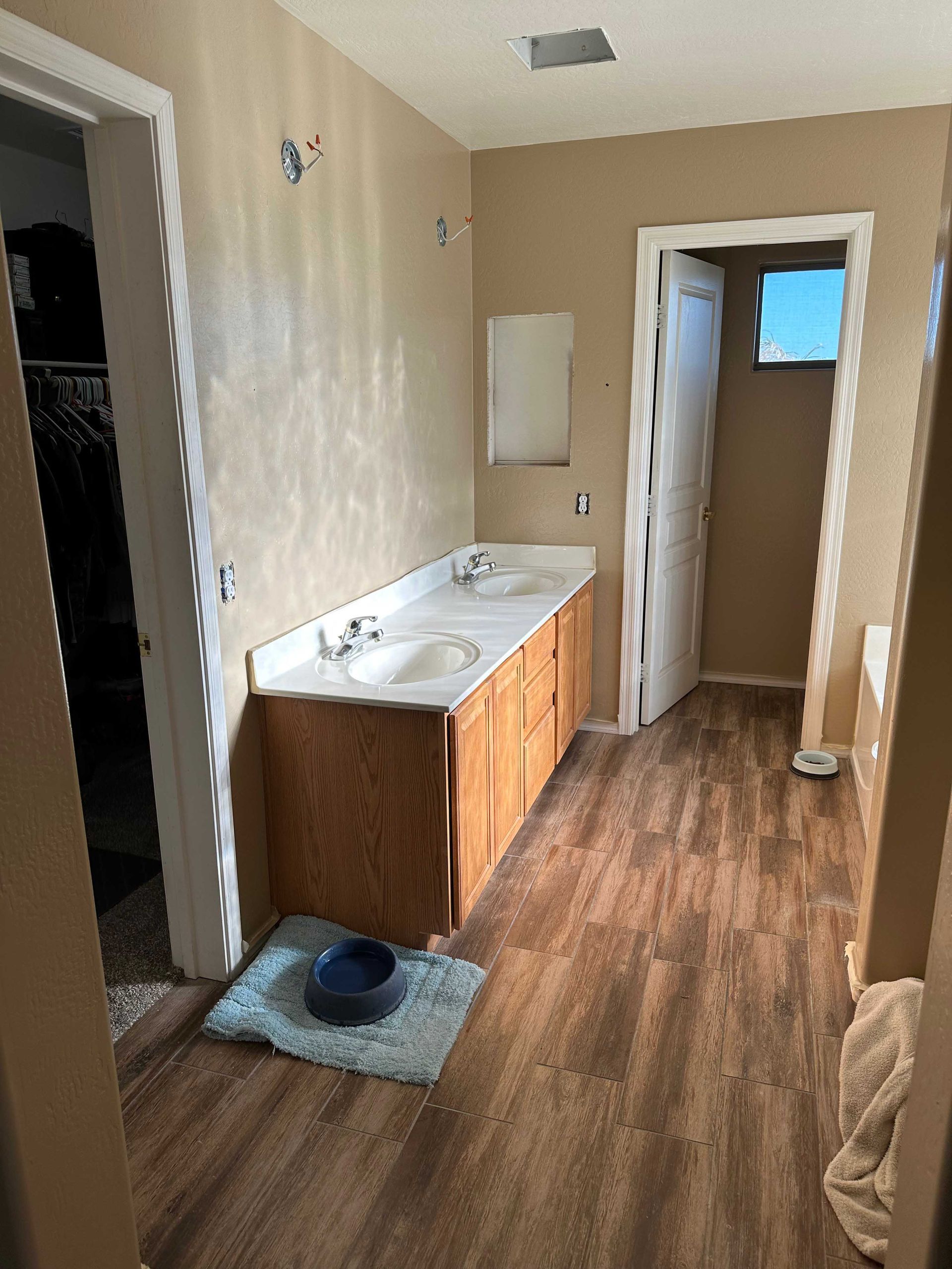 A bathroom with two sinks and a rug on the floor.