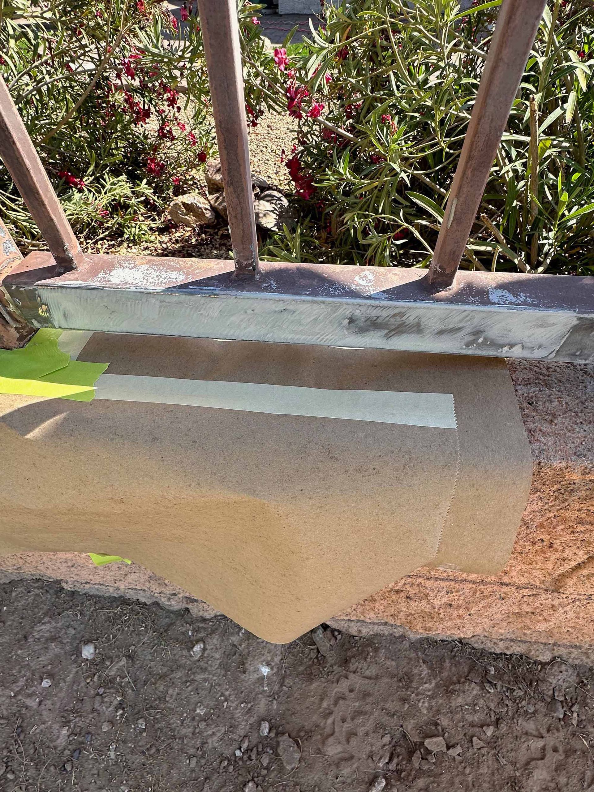 A metal railing is sitting on top of a concrete surface.