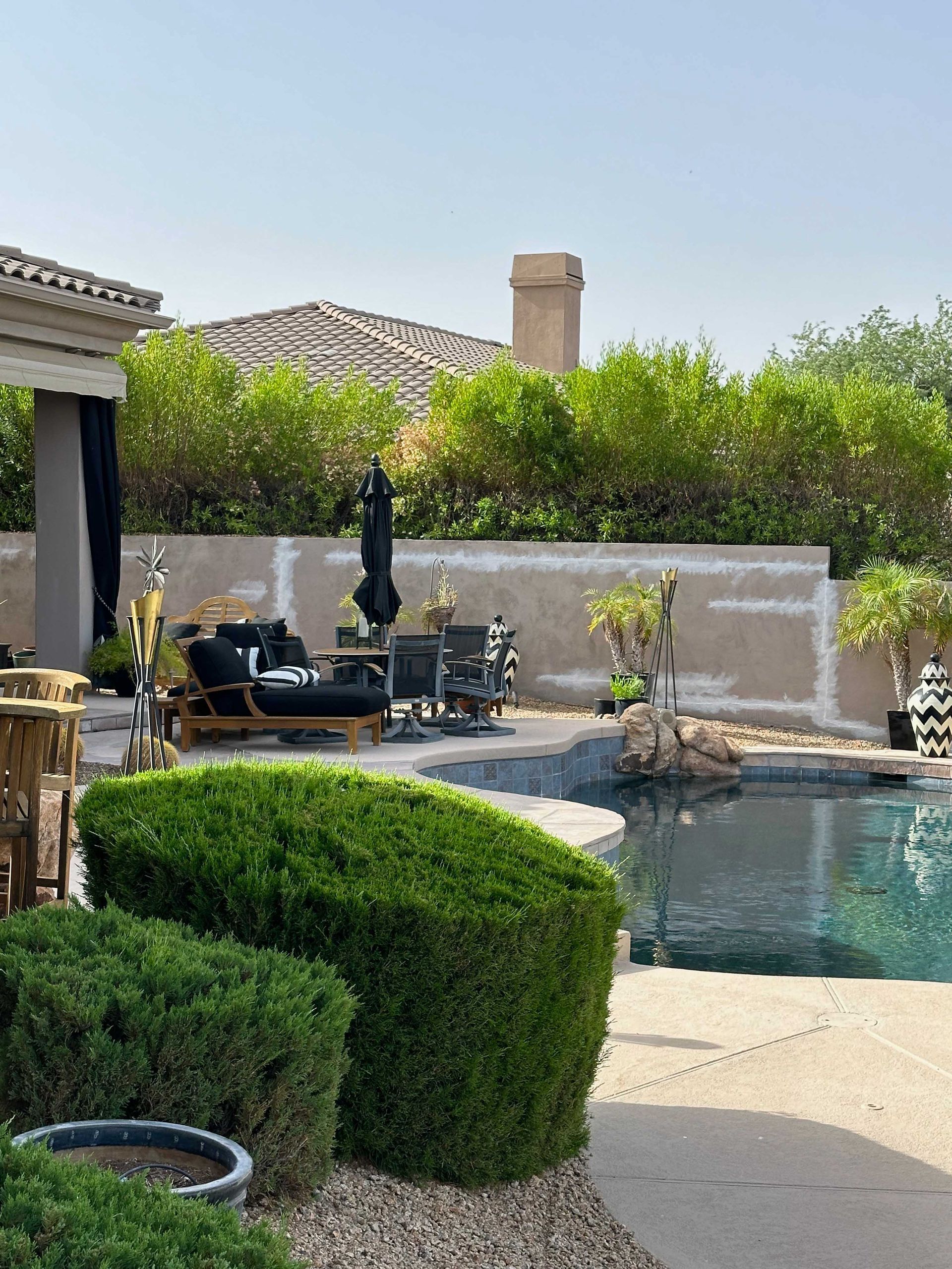 A backyard with a swimming pool and patio furniture