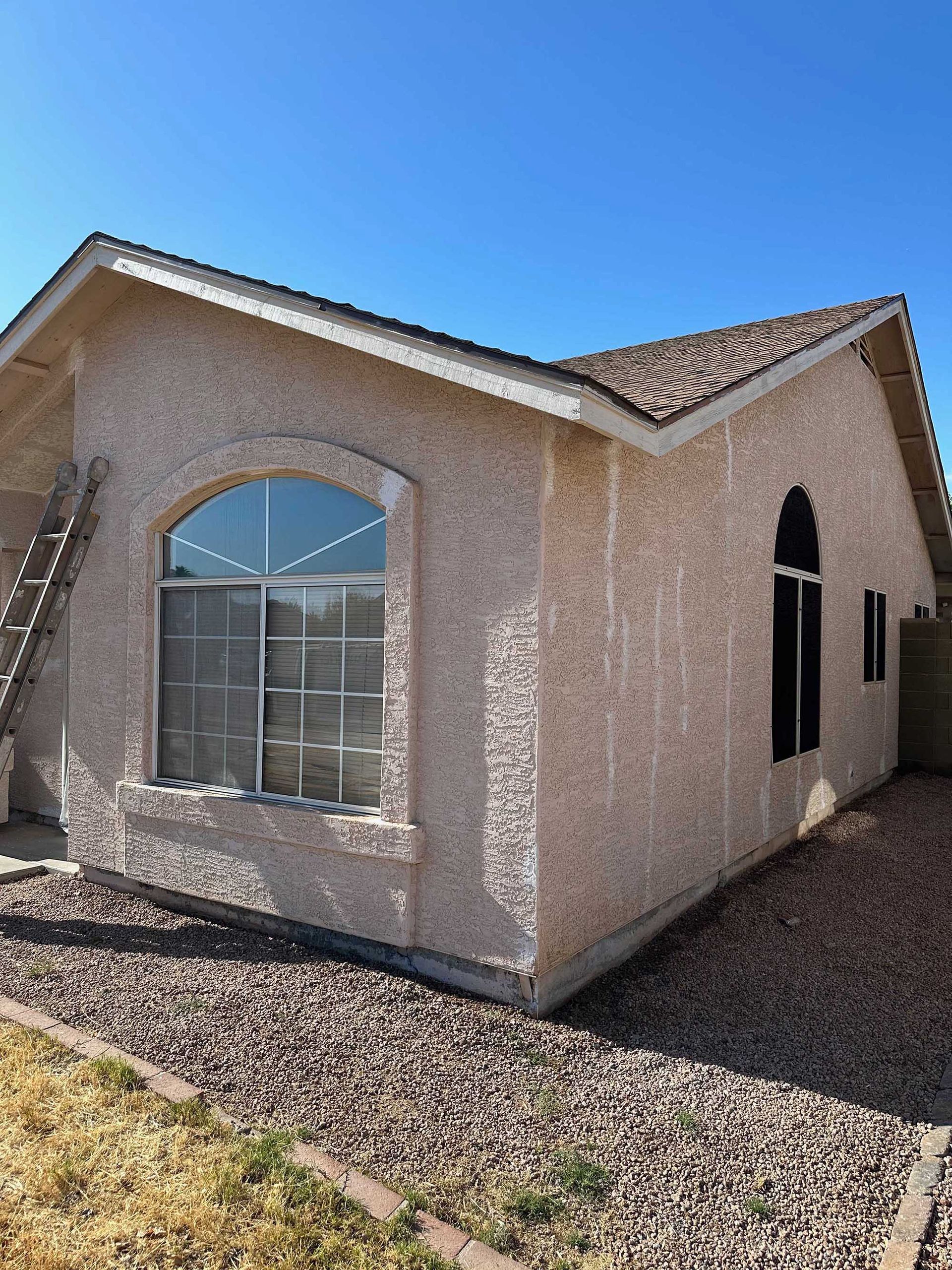 A small house with a ladder on the side of it