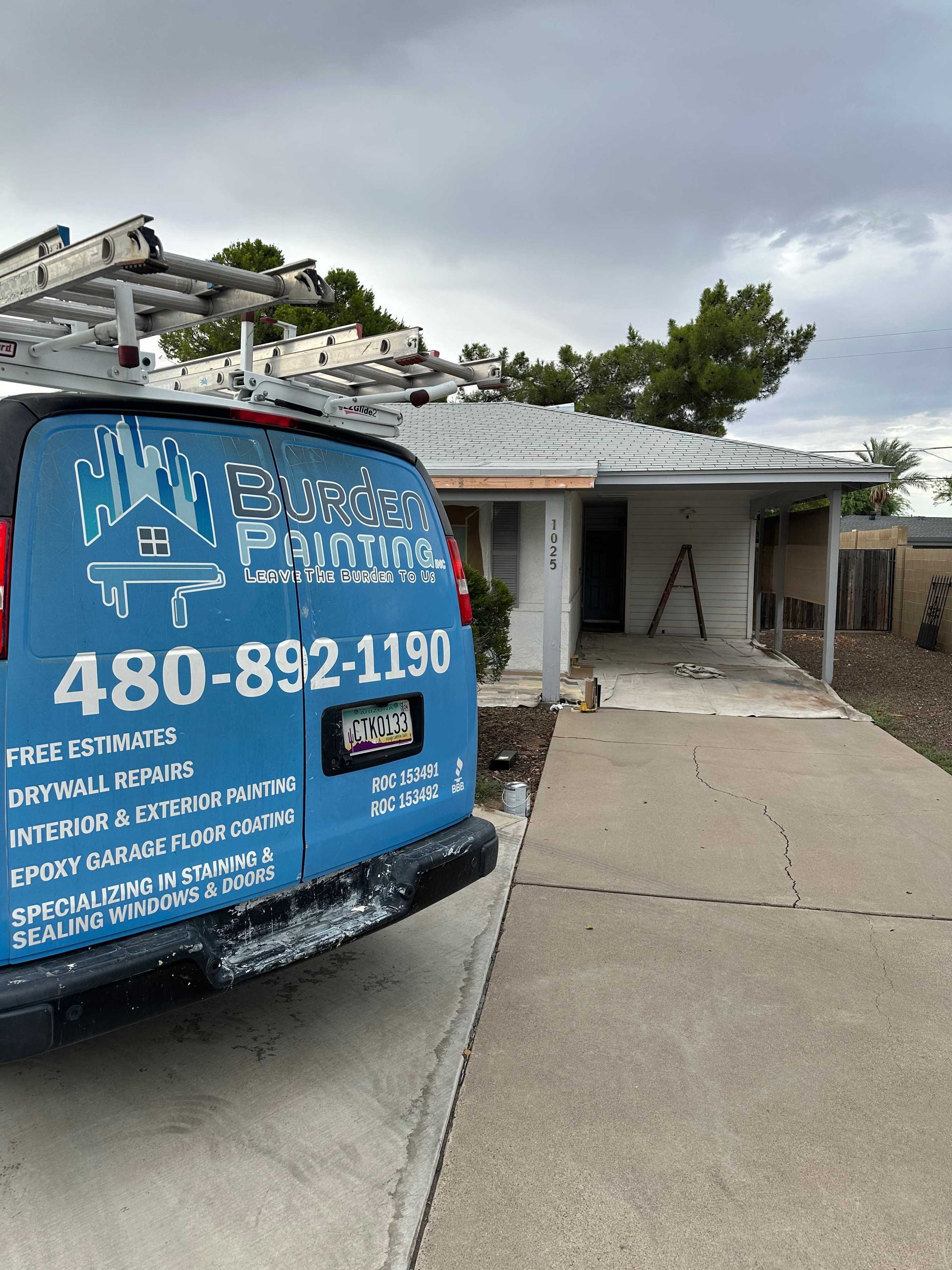 A blue van is parked in front of a house.