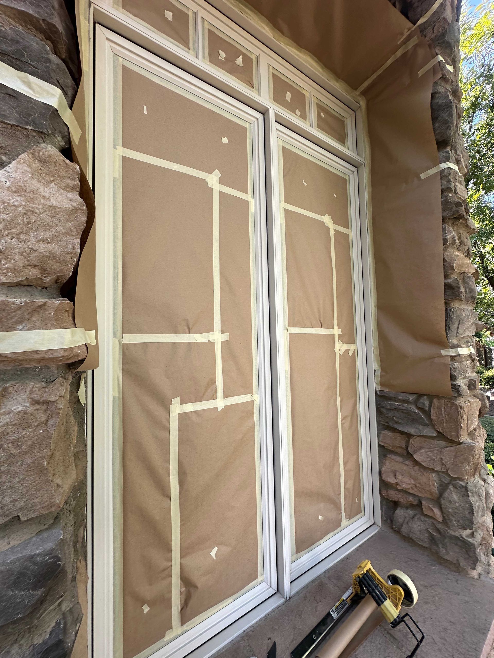 A window is being painted on a stone wall.