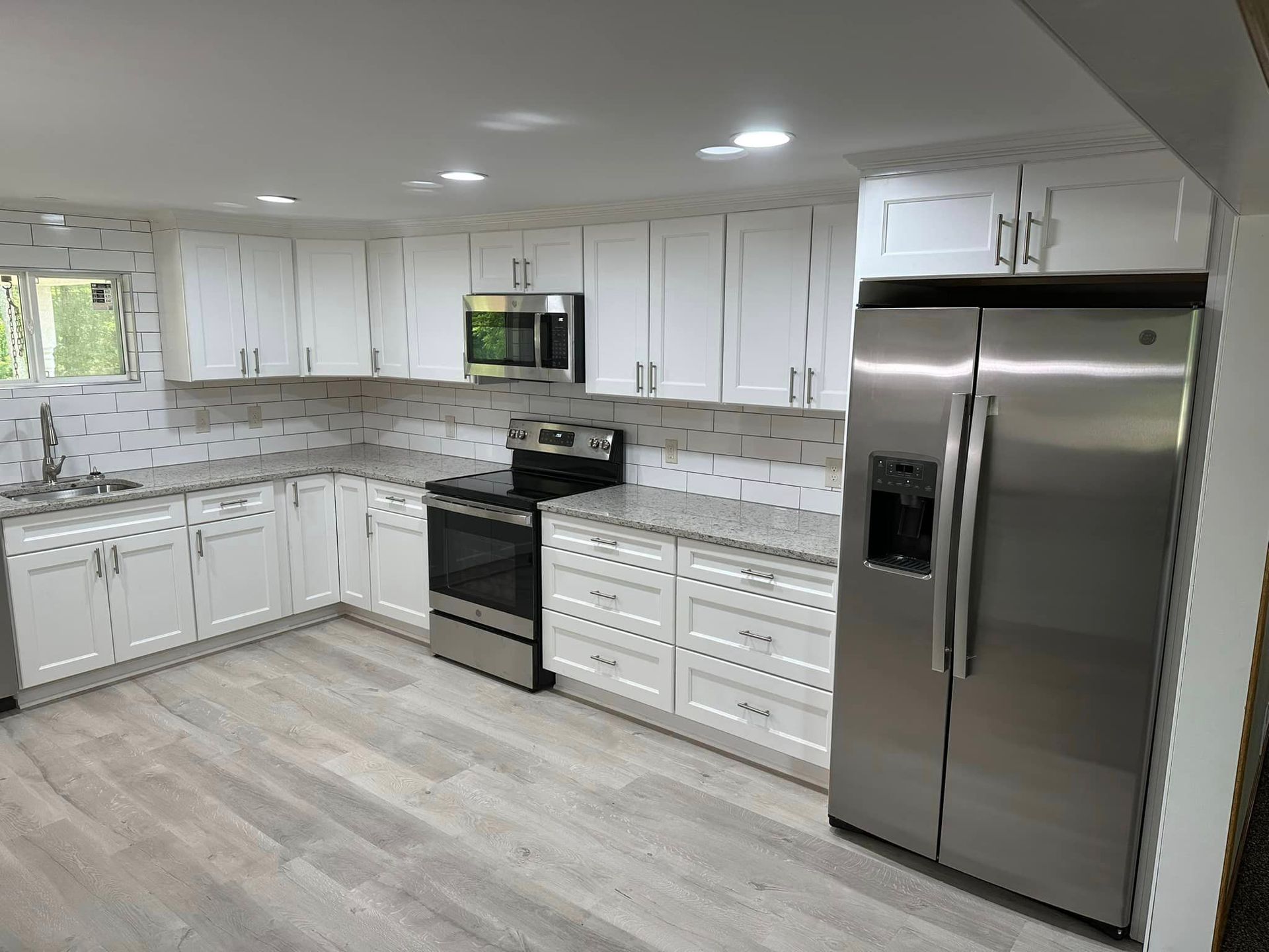 A kitchen with white cabinets and stainless steel appliances.
