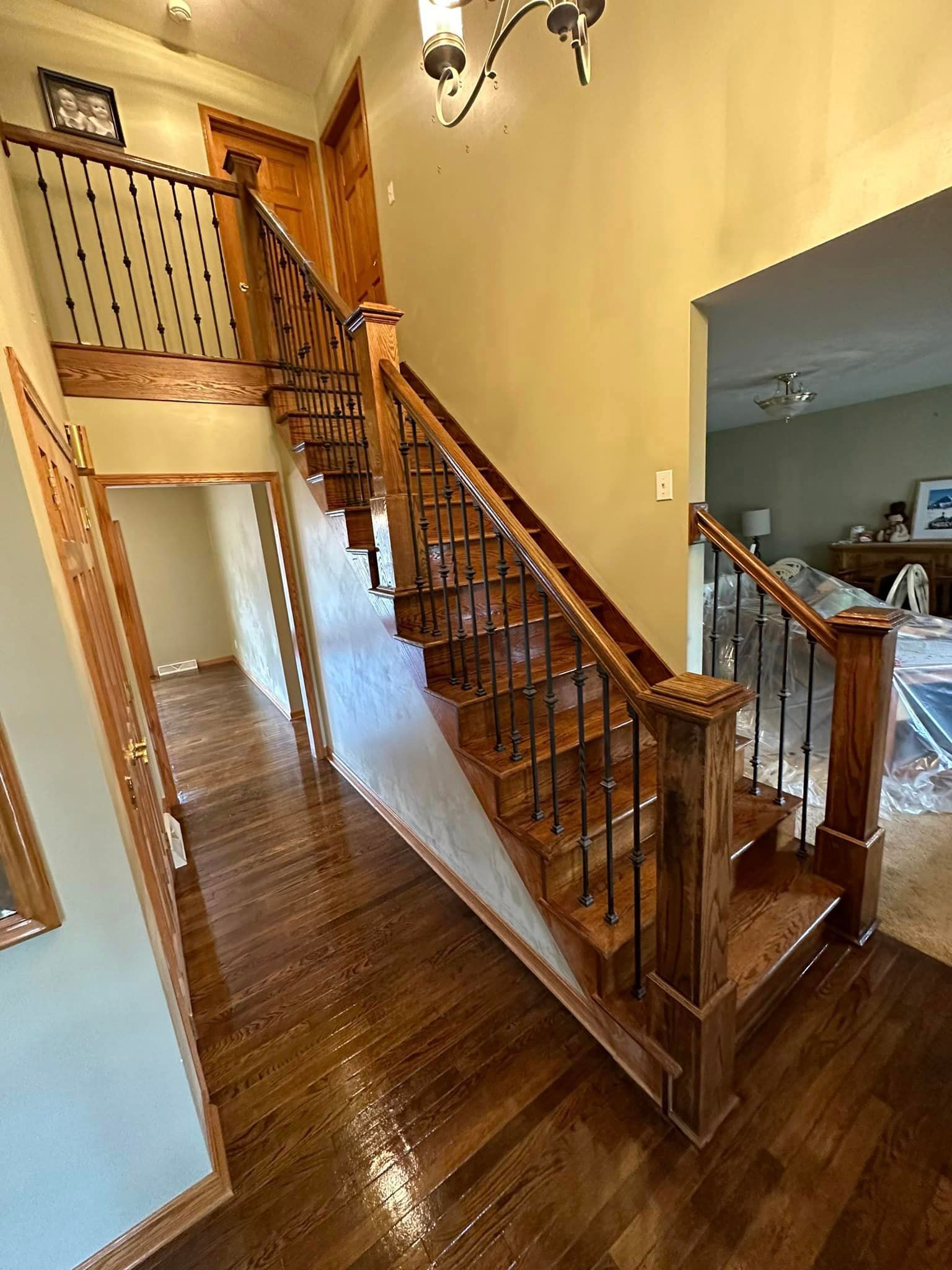 A wooden staircase with a metal railing in a house.