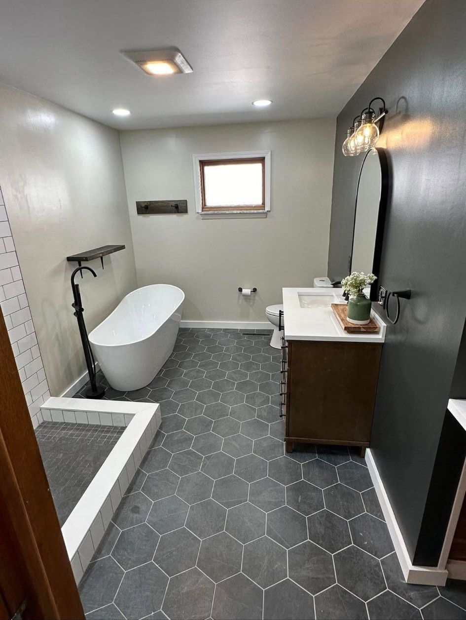 A bathroom with a tub, sink, and shower.