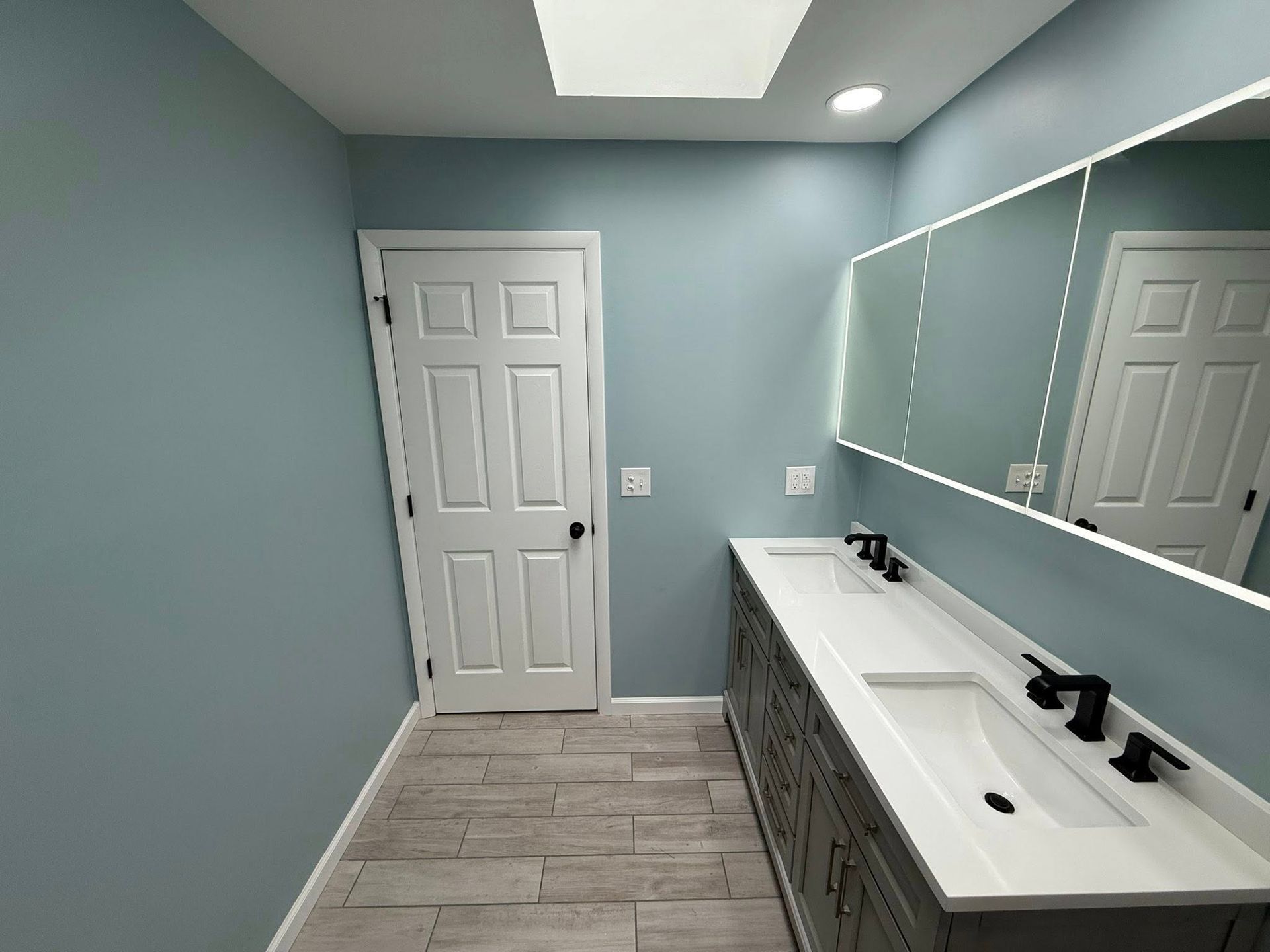 A bathroom with two sinks and a large mirror.