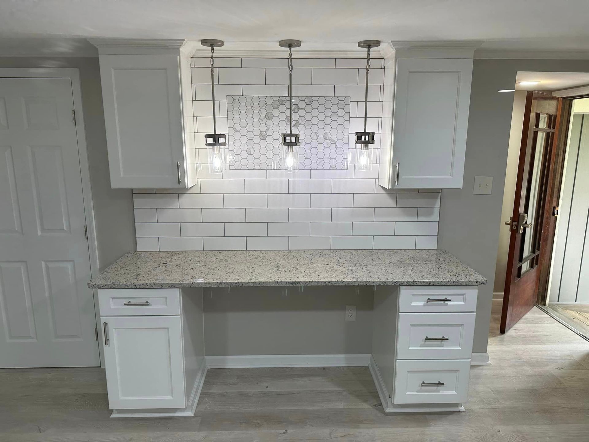 A kitchen with white cabinets and a granite counter top.