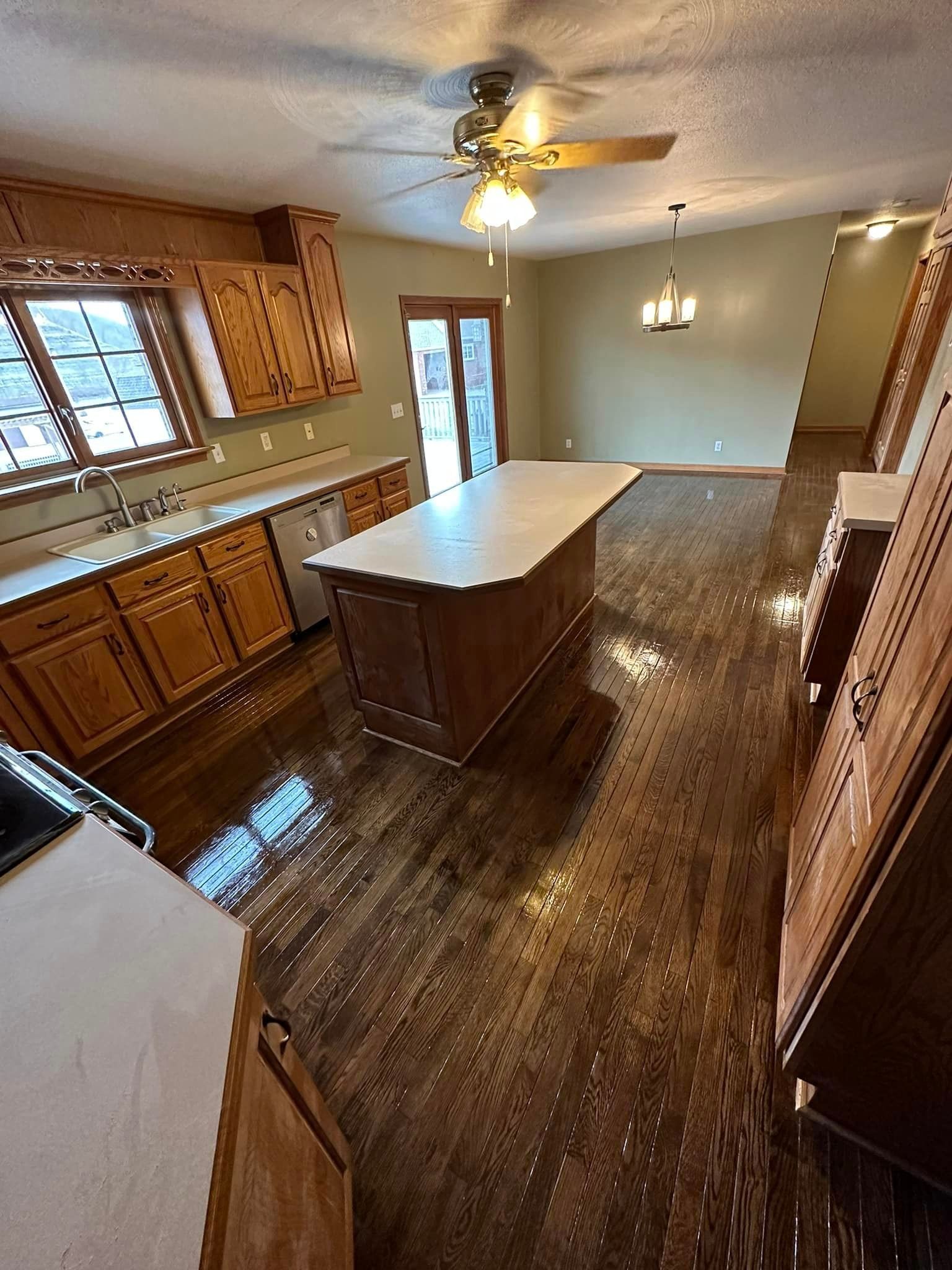 A kitchen with a large island and a ceiling fan.