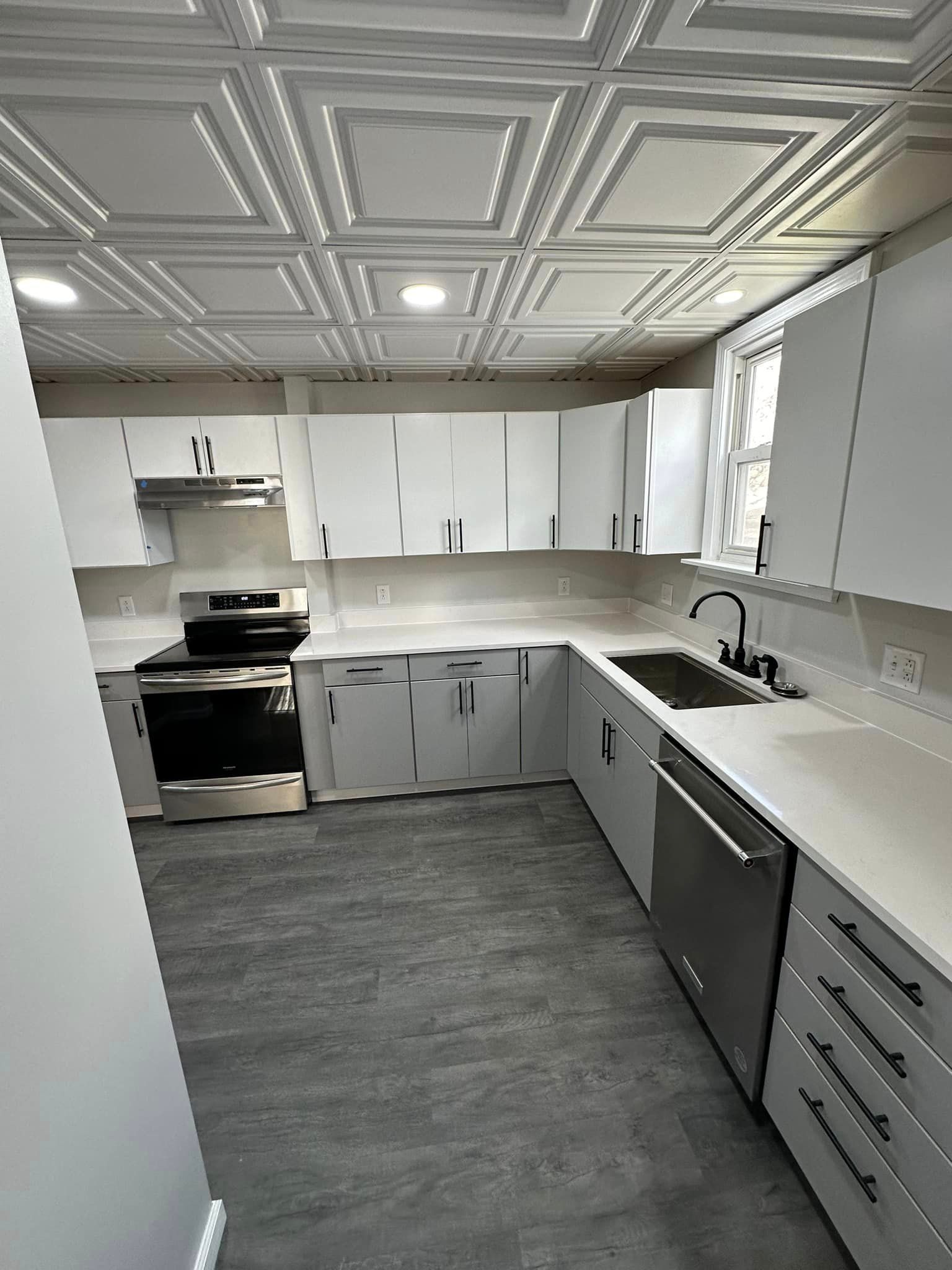 A kitchen with white cabinets , stainless steel appliances , a sink , and a stove.