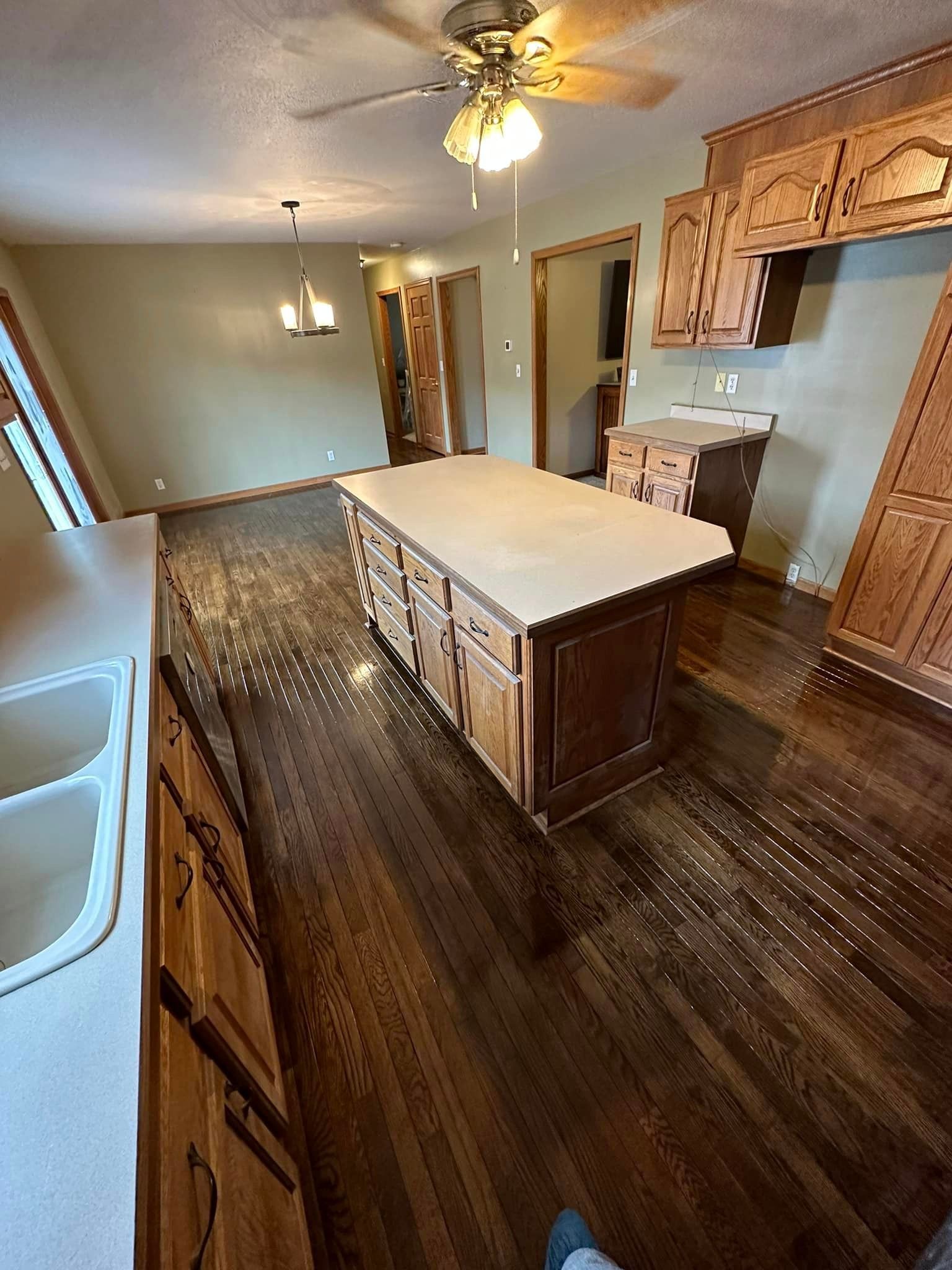 A kitchen with a large island and a ceiling fan.