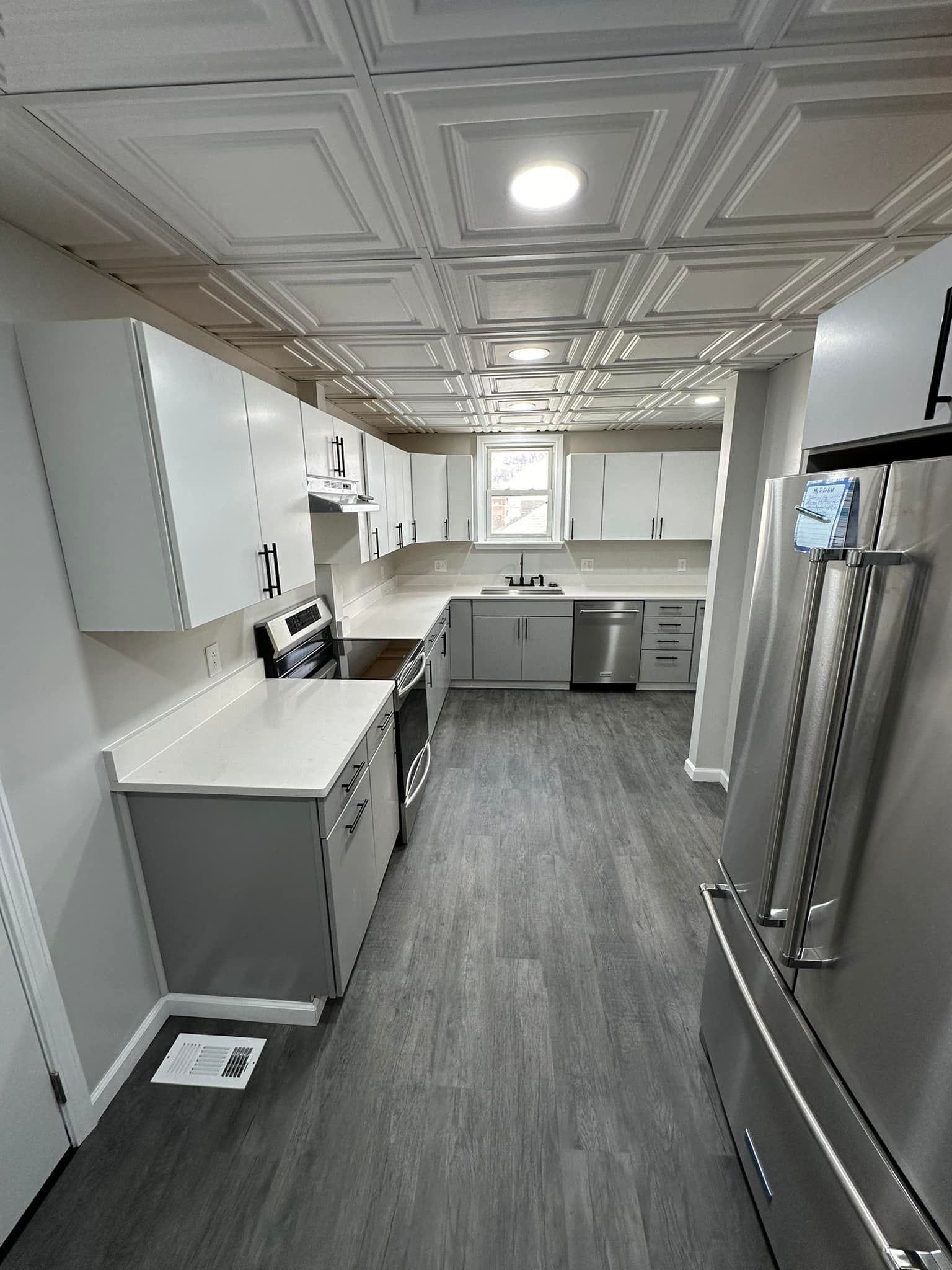 A kitchen with stainless steel appliances and white cabinets.