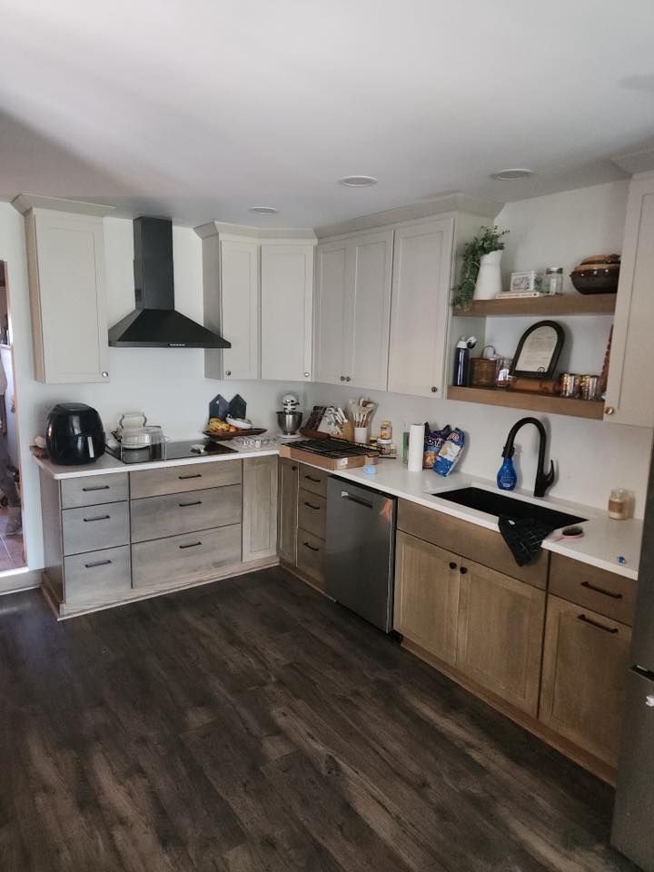 A kitchen with white cabinets, stainless steel appliances, a sink, and a stove.