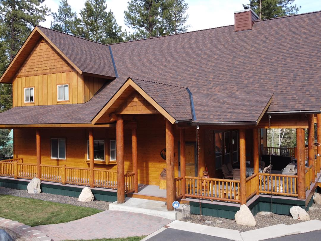 A large wooden house with a porch and a roof