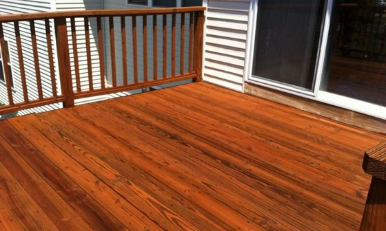a wooden deck with a railing and a sliding glass door