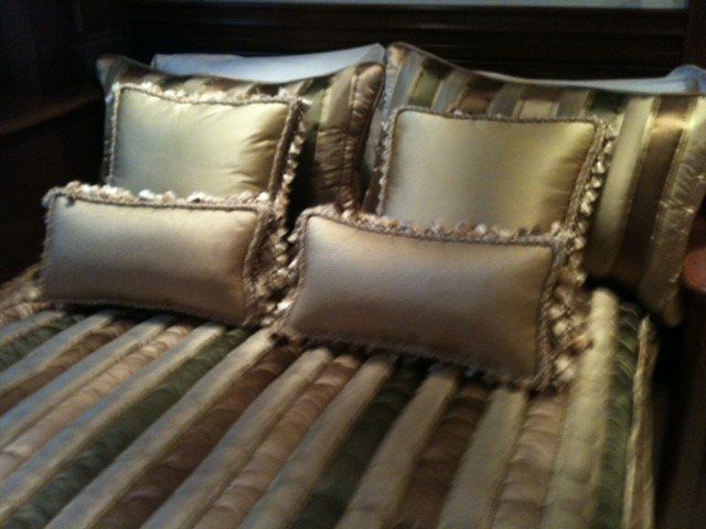 A bed with a striped comforter and pillows on it