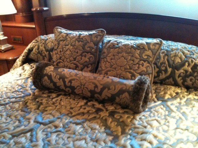 A bed with a patterned blanket and pillows on it